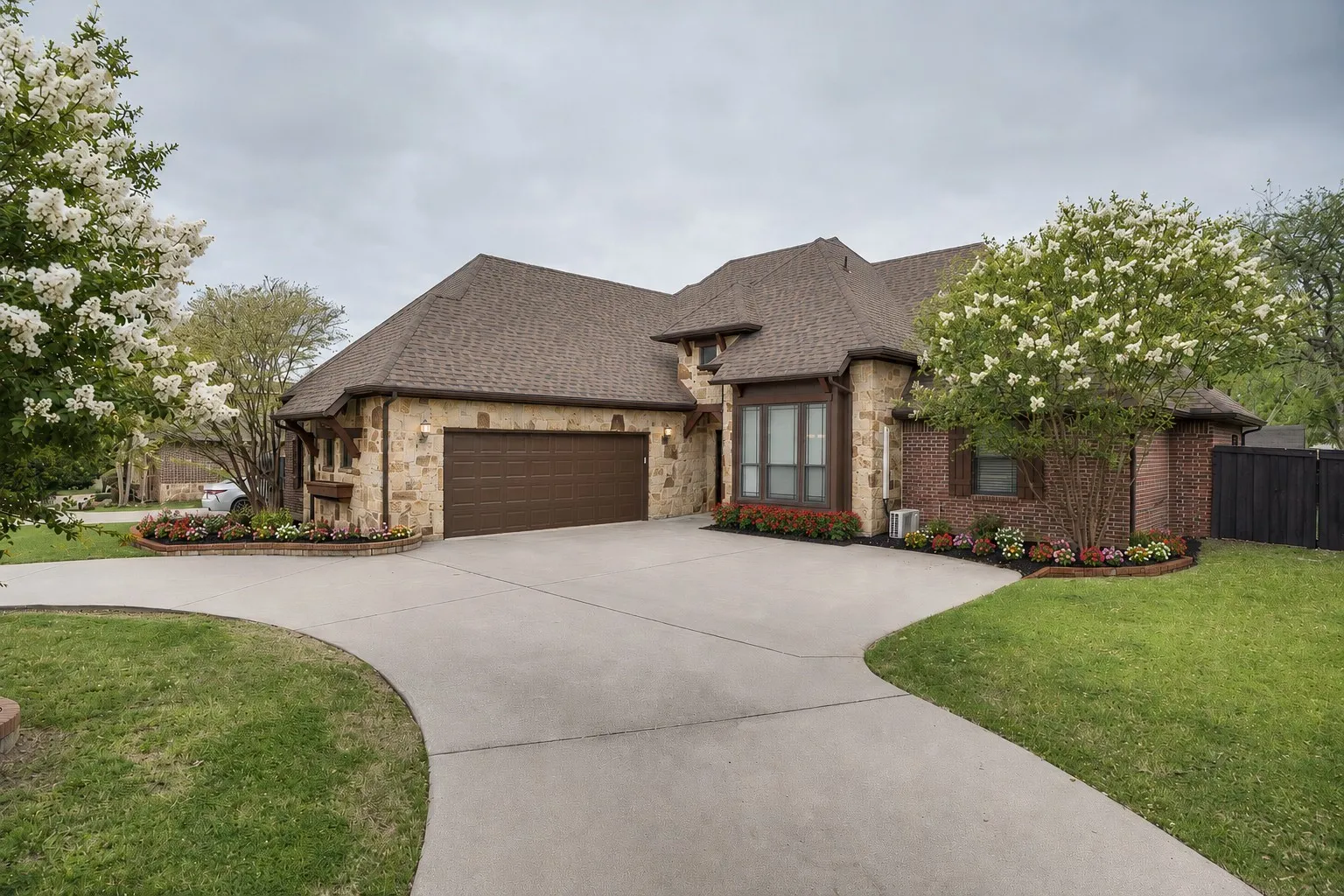 Stone and brick exterior with a brown shingle roof