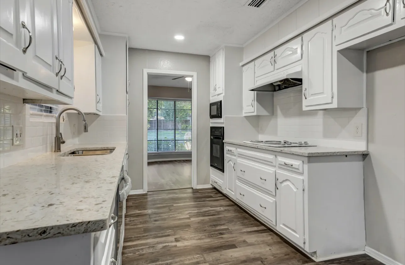 Kitchen featuring decorative backsplash, white cabinetry, dark wood-style floors, and recessed lighting