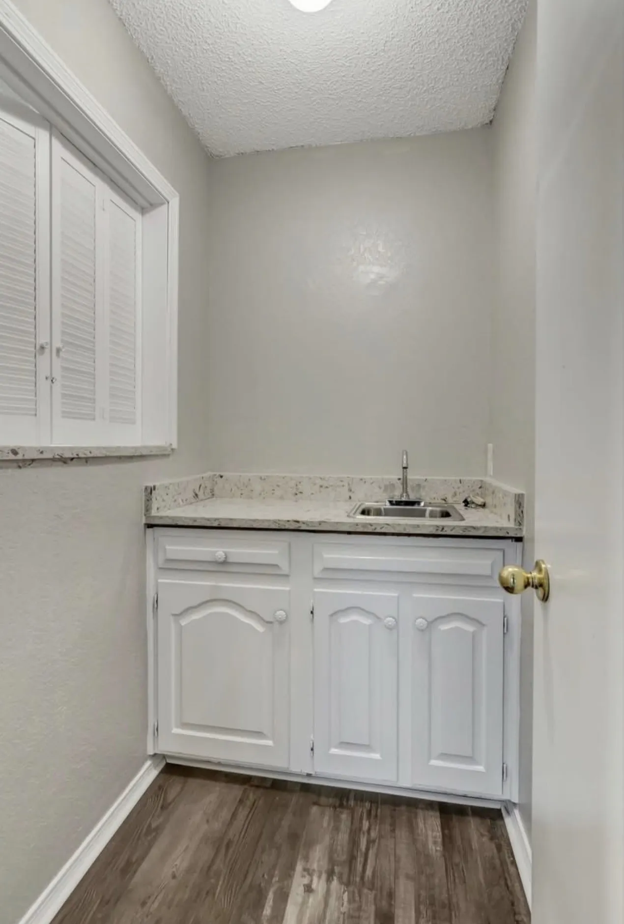 Bathroom with vanity, dark wood finished floors, and a textured ceiling