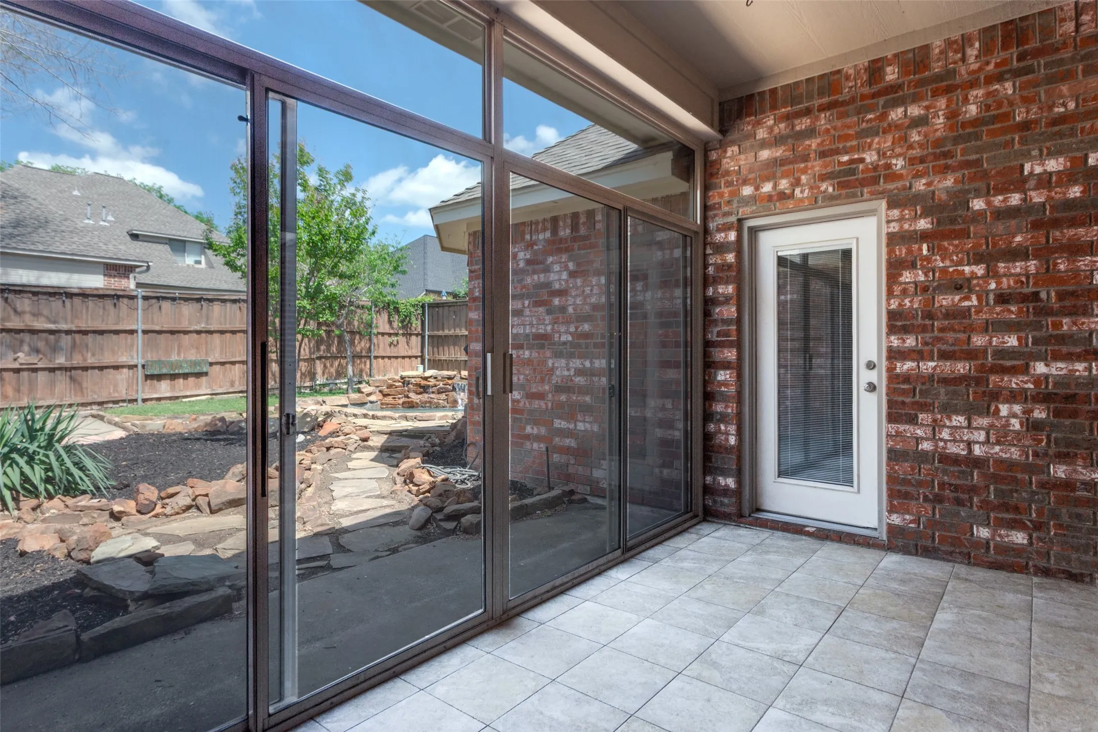 Sun room overlooking the pool with a double glass doors  and separate entry into the primary suite.
