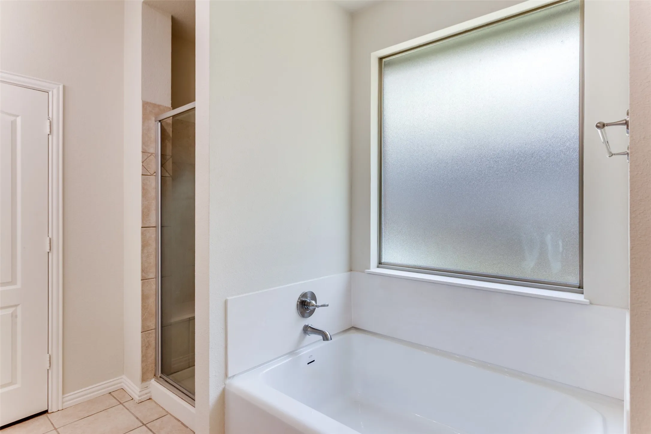 Primary Bathroom with new soaking tub, a large separate shower, and light tile patterned floors
