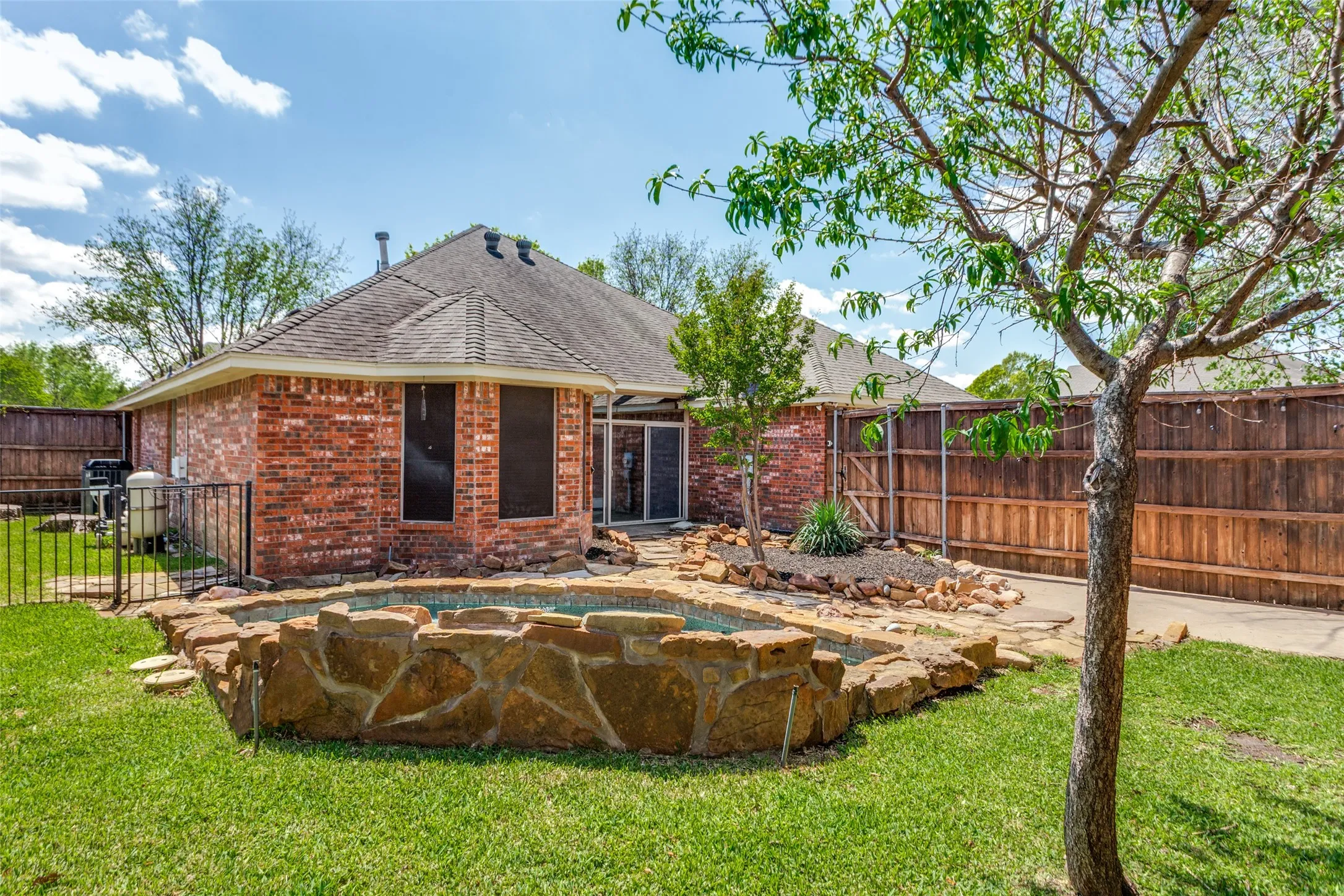 Green grass in the back yard overlooking the pool.