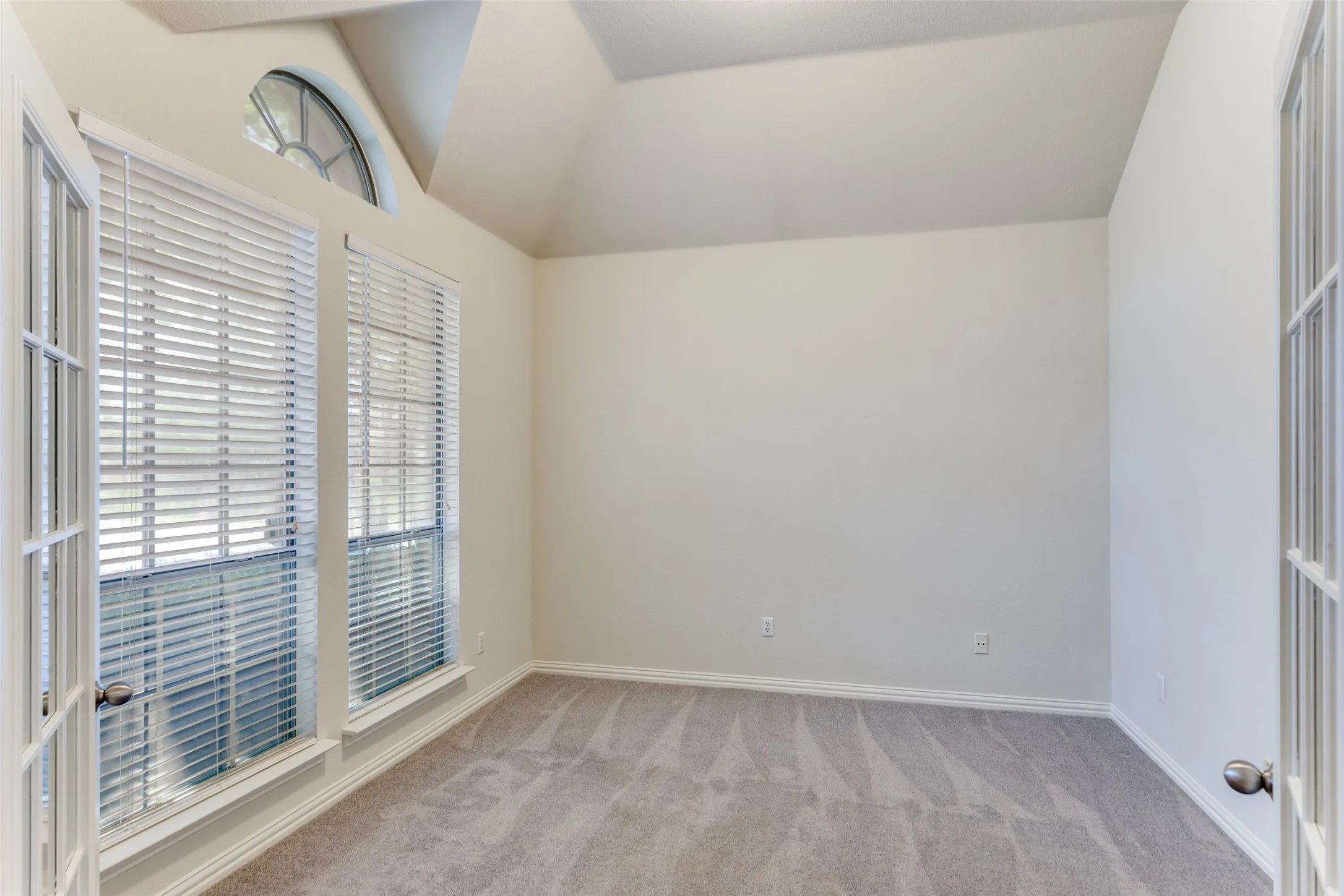 front office with lofted ceiling and light colored carpet