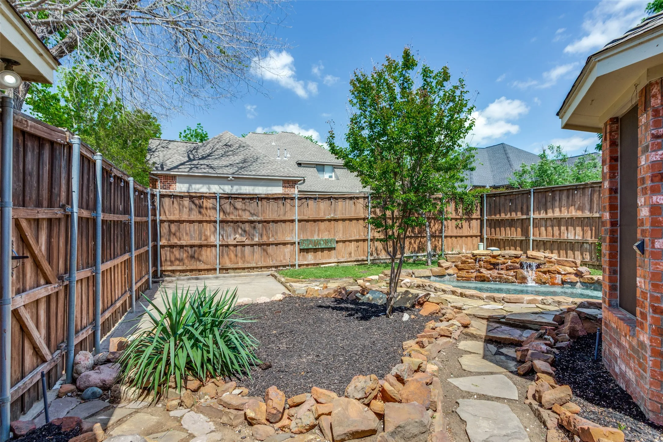 Beautiful wooden fenced back yard with professional landscaping.