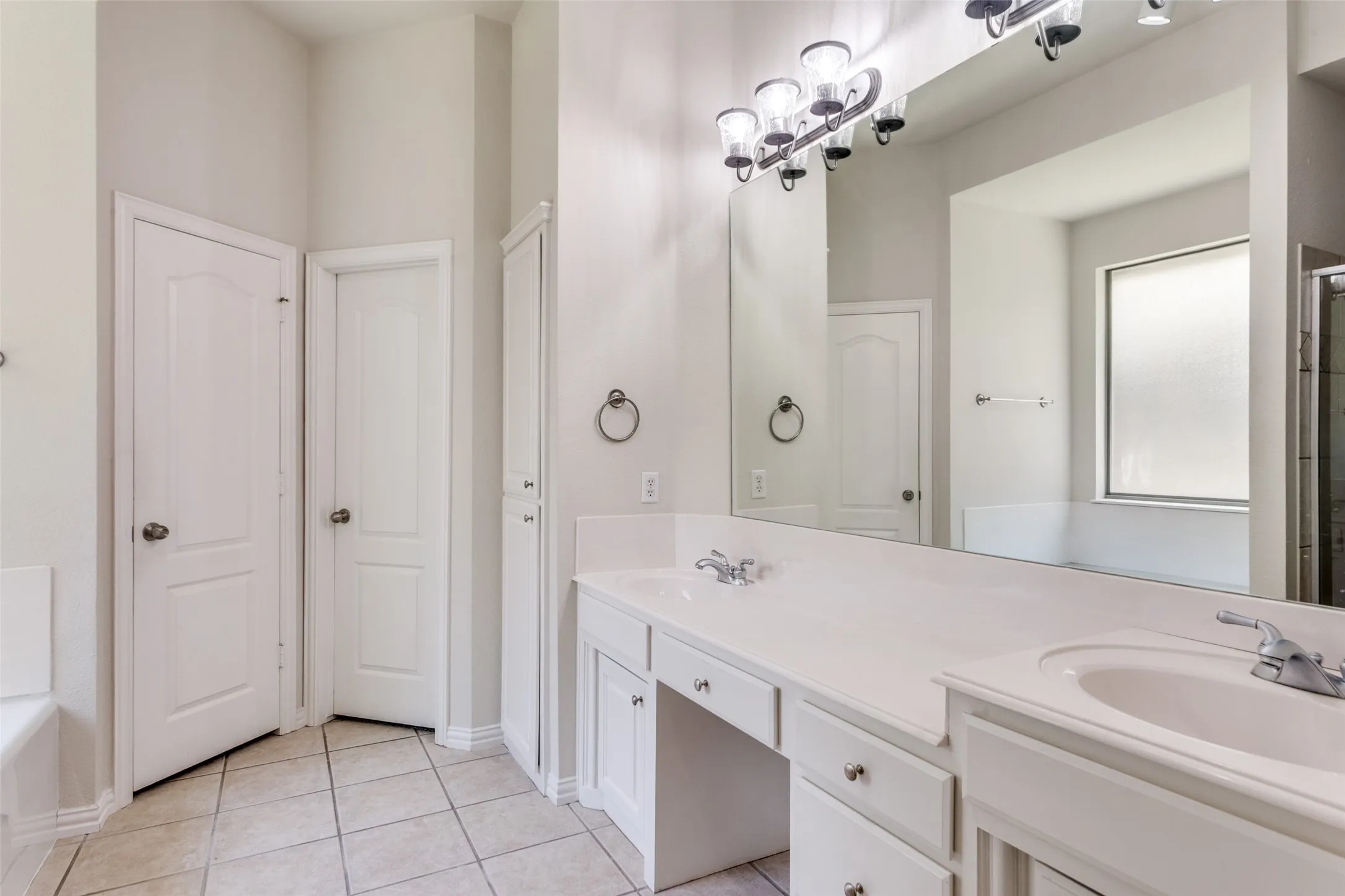 Bathroom with double vanity, light tile patterned floors, a shower, and a bathtub