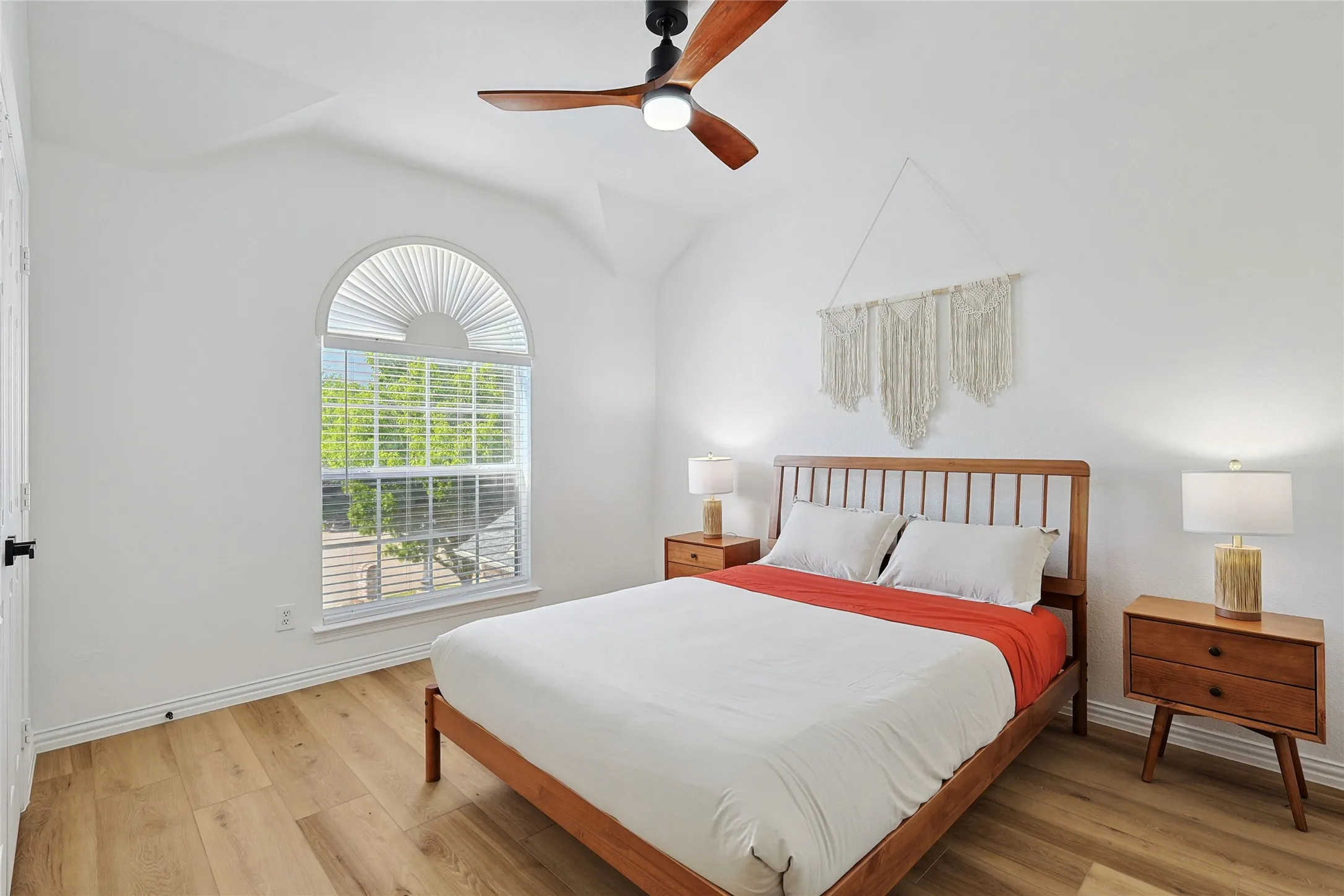 Bedroom featuring light hardwood / wood-style floors, lofted ceiling, and ceiling fan