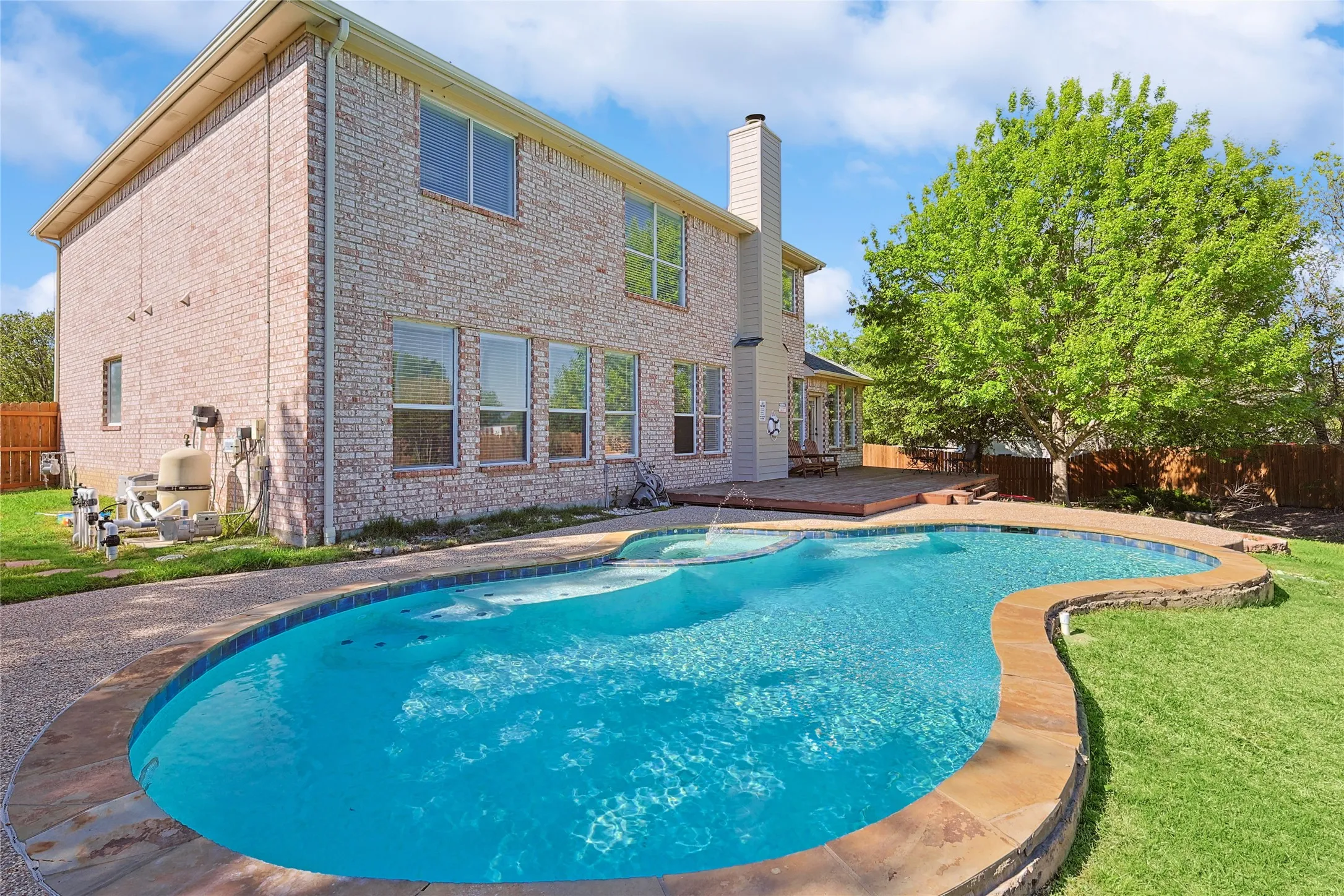 View of swimming pool featuring a lawn and a wooden deck