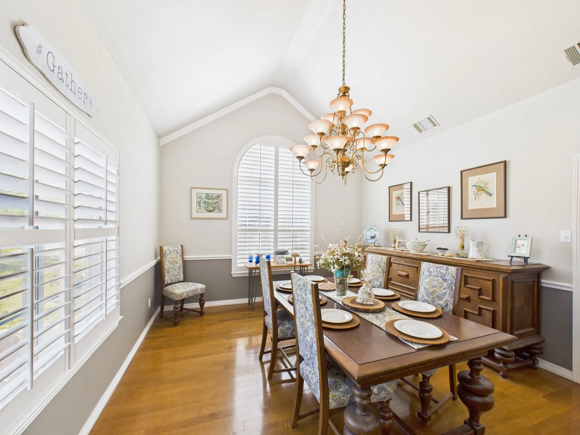 Gorgeous formal dining room with wood floors and a high ceiling, designer light, chair rail, window shutters