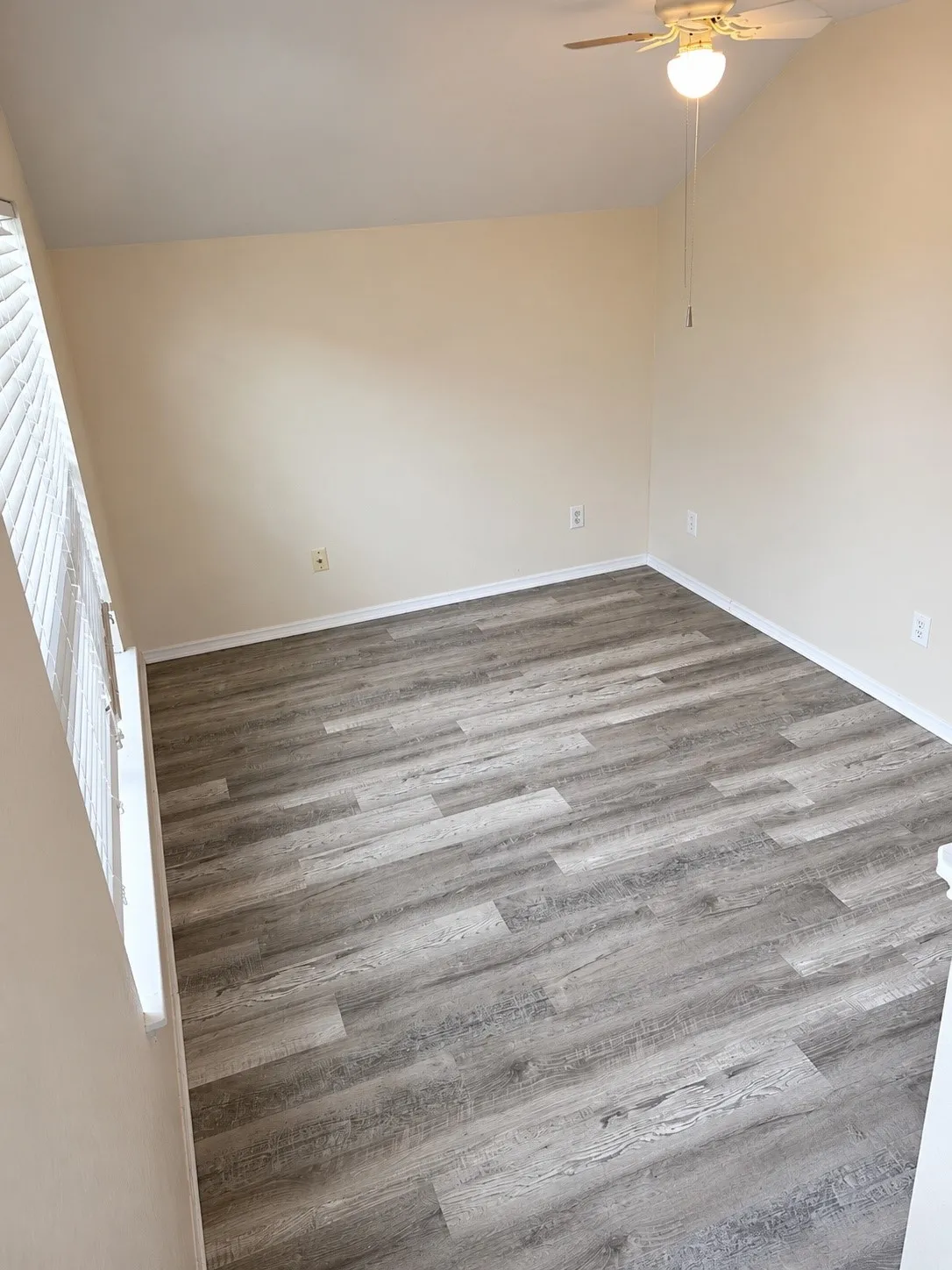 Office featuring wood-finish flooring, vaulted ceiling, and a ceiling fan with integrated lighting