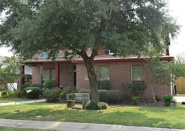 Traditional-style house featuring a front yard and brick siding