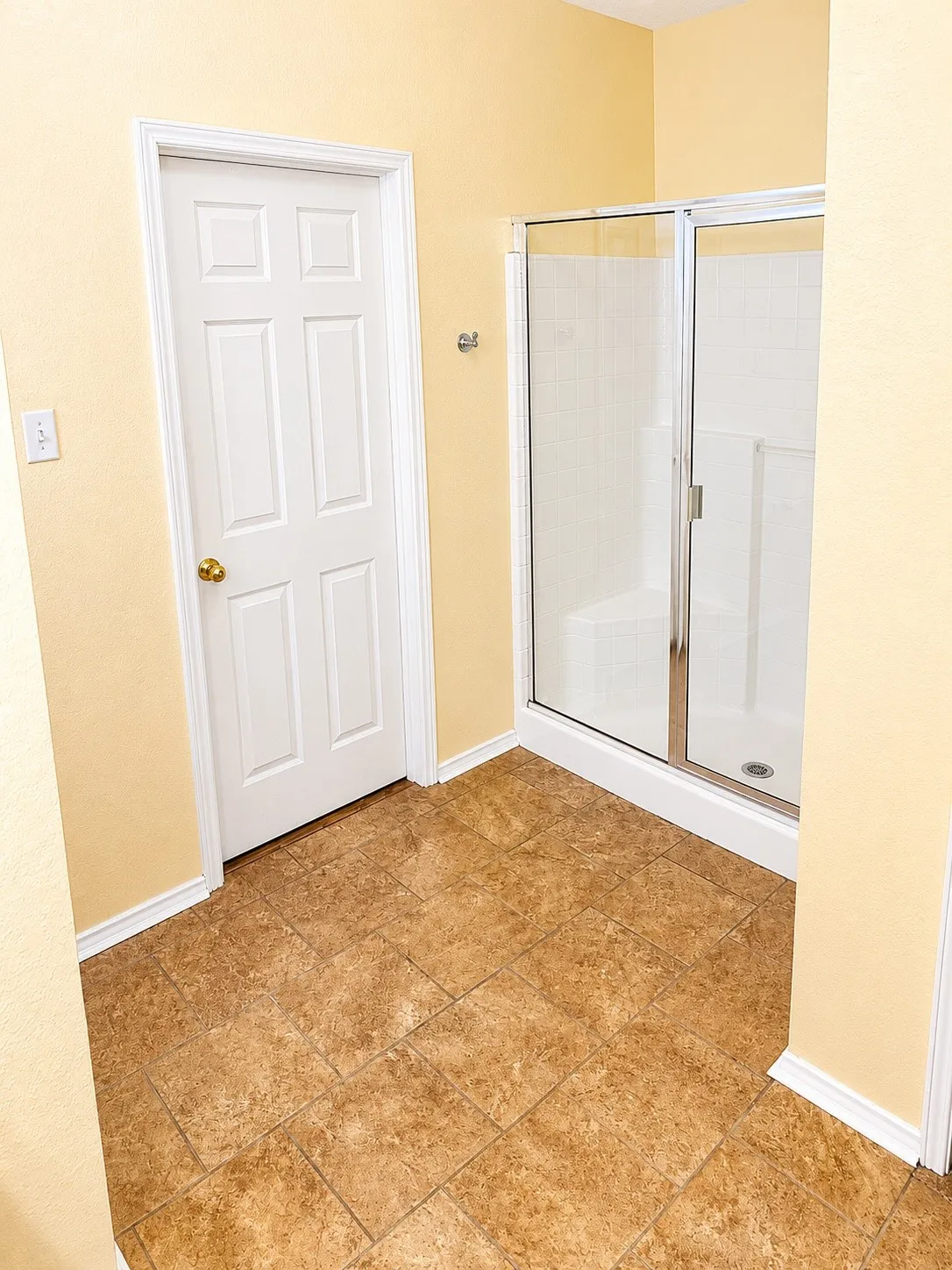 Walk-in shower with clear glass enclosure and white base