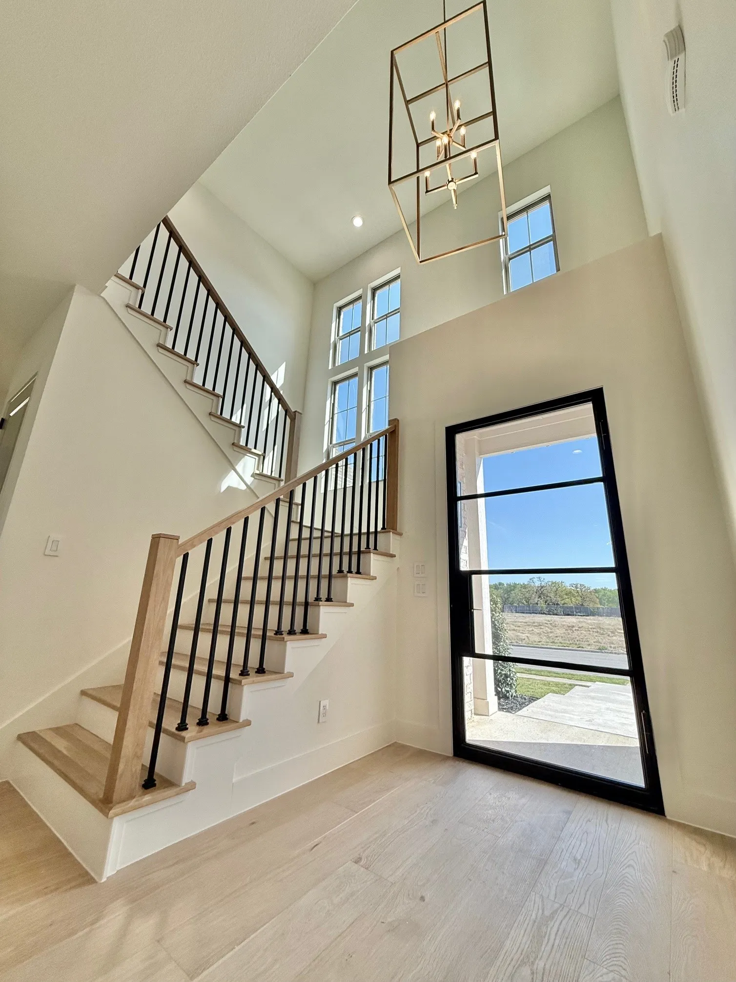 Entrance Foyer. Steel Front door, tall ceilings and handcrafted staircase with white oak treads