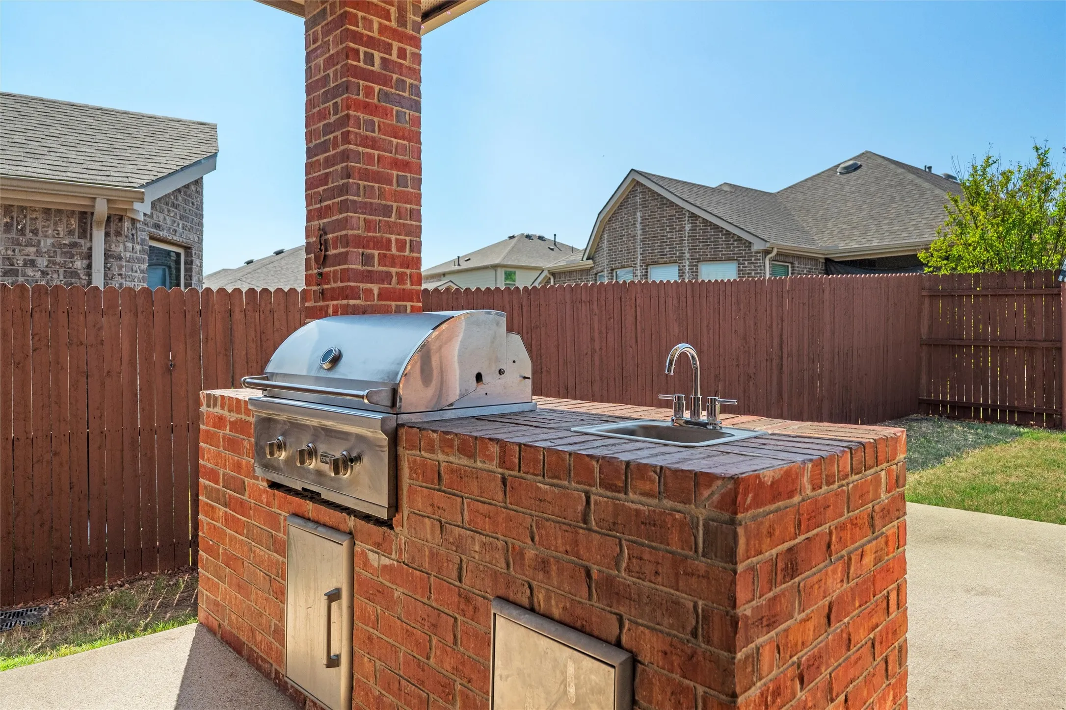 Outdoor kitchen with built-in grill, sink, and cable hookup