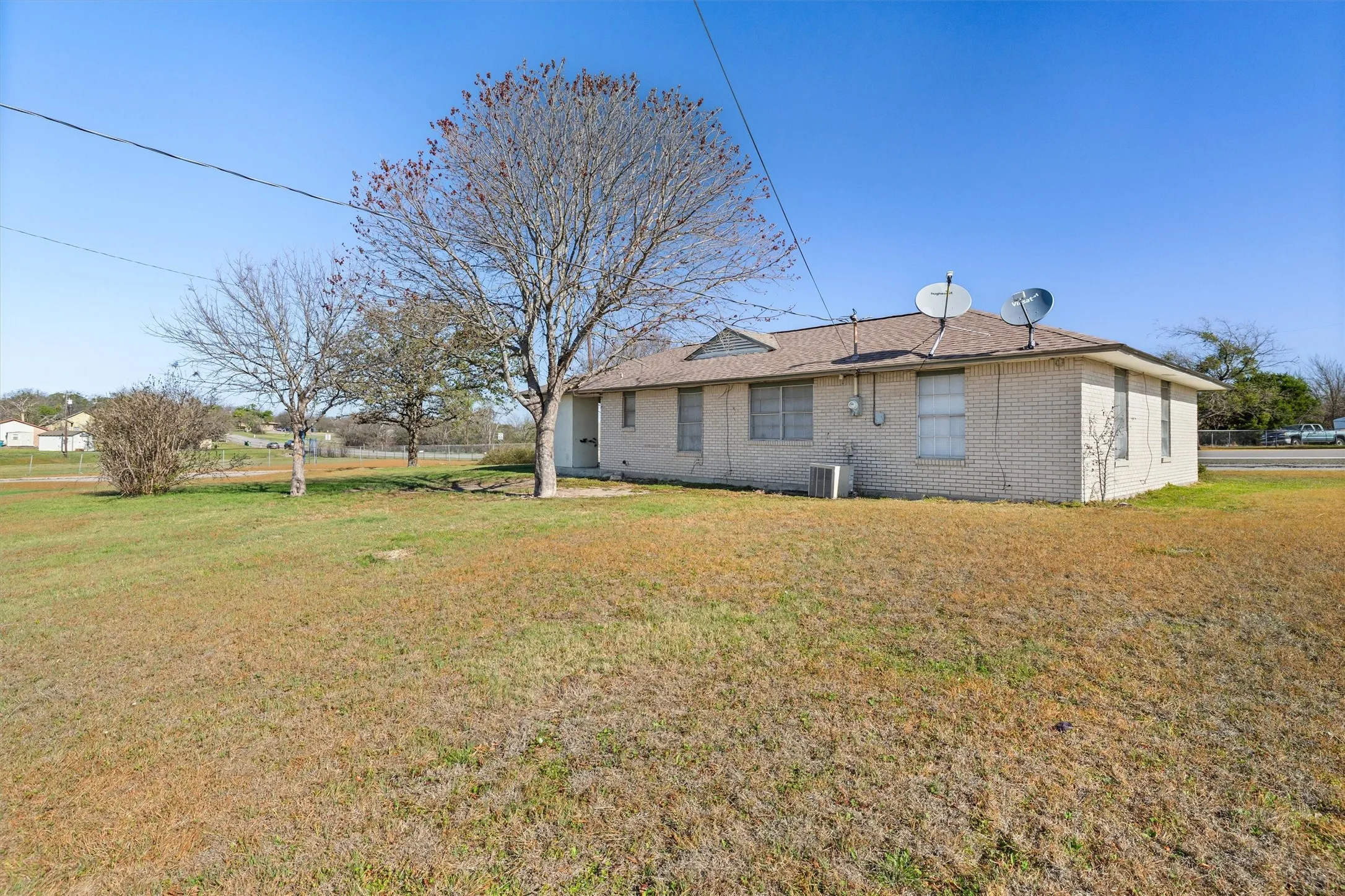Rear view of property with brick siding and a yard