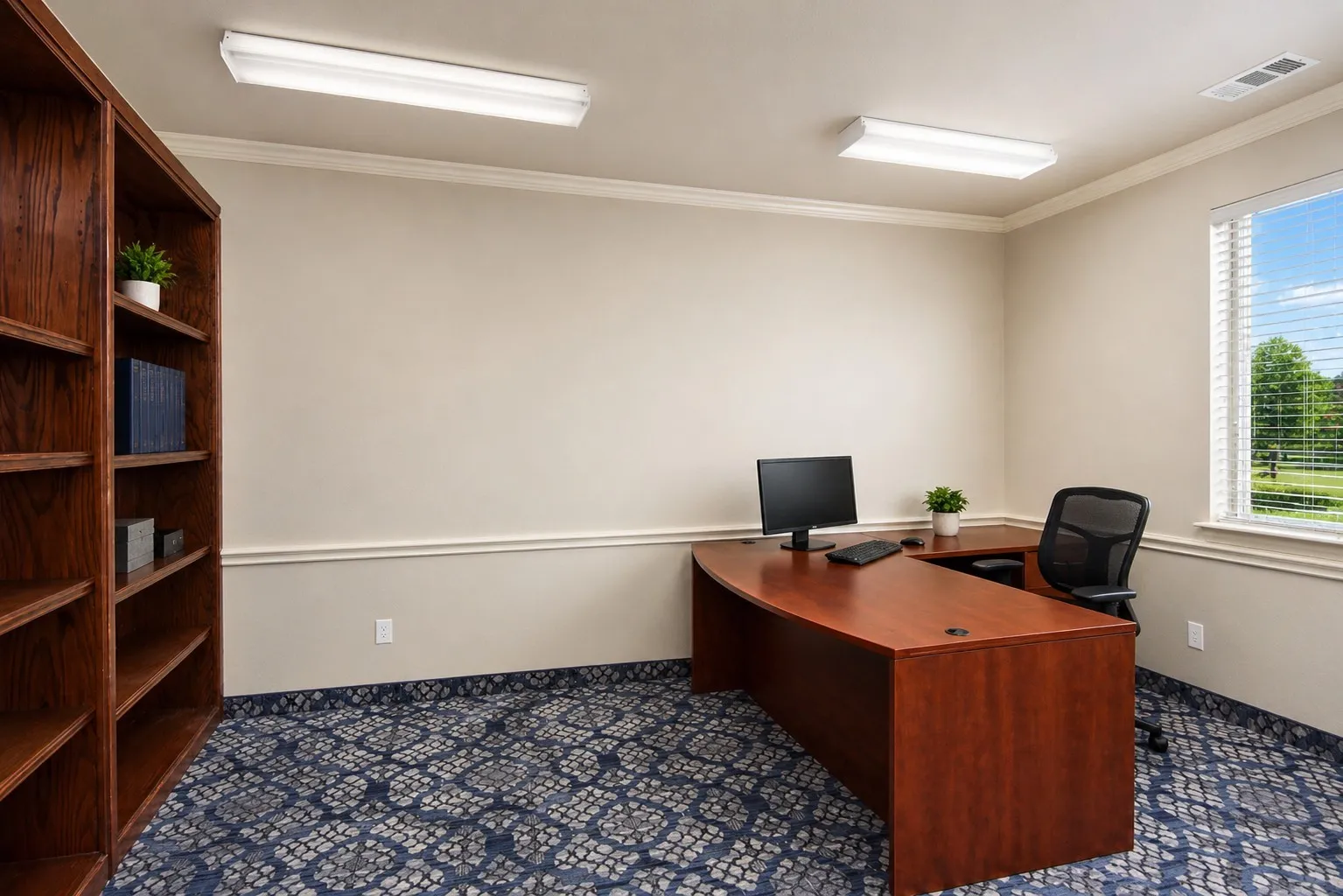 Room featuring a built-in wood-finish shelving unit, patterned carpet flooring, a window with blinds, and crown molding