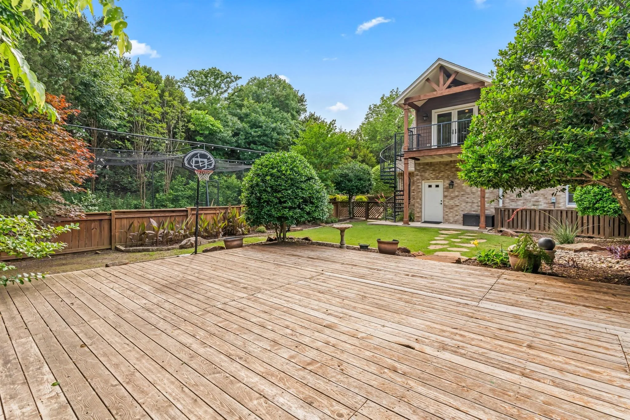 Deck featuring a fenced backyard, a patio, and view of wooded area