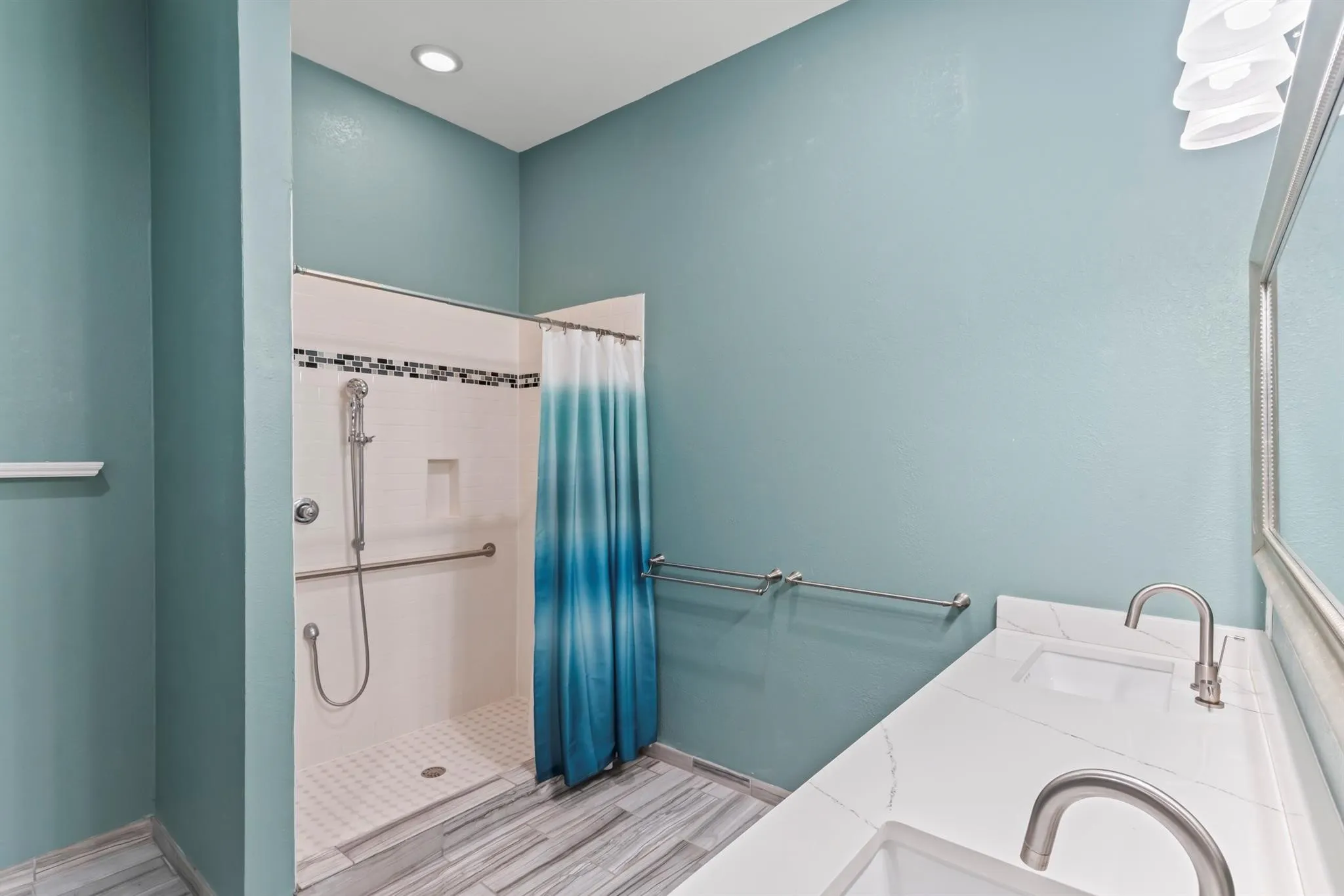 Full bath featuring double vanity, a shower stall, and wood tiled floors