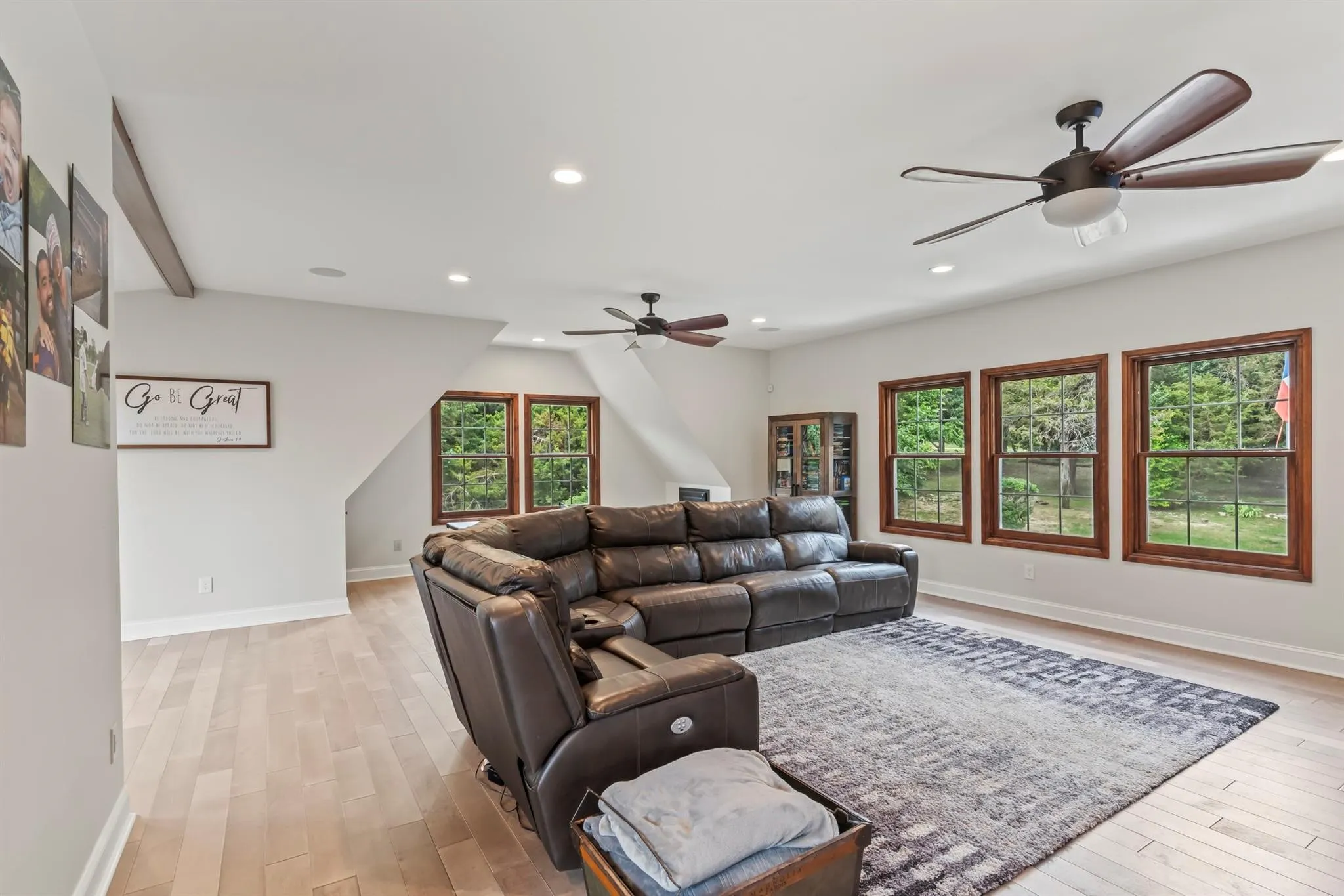 Living area with light wood-type flooring, a ceiling fan, and recessed lighting