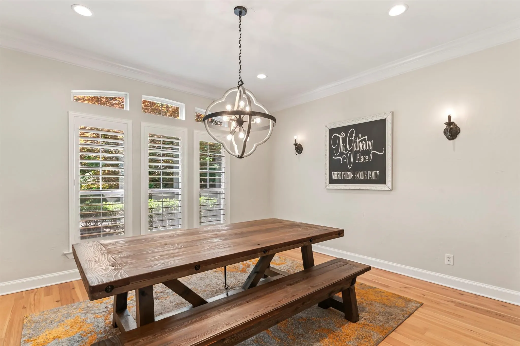 Dining area with crown molding, light wood-style flooring, and a chandelier