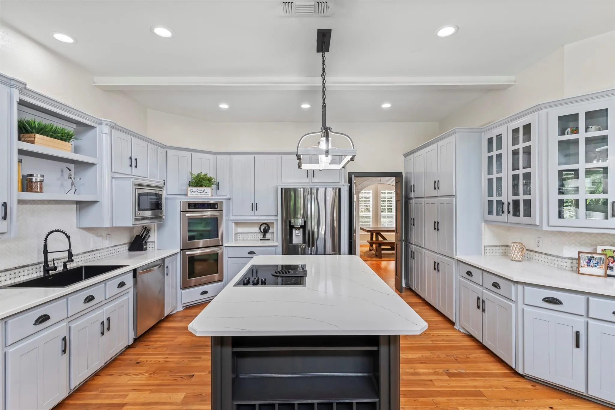 Kitchen with open shelves, a center island, gray cabinets, and beam ceiling