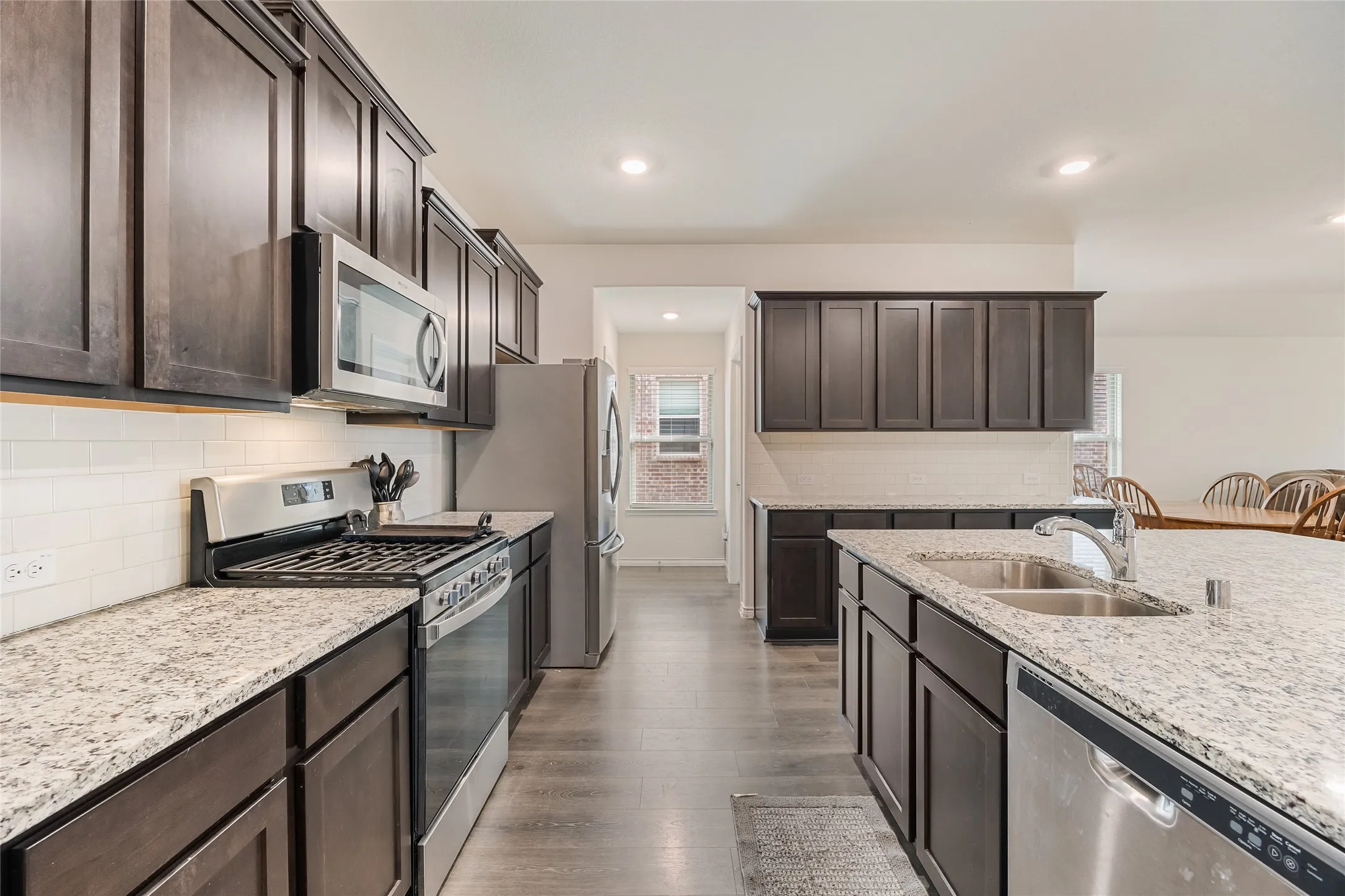 Kitchen boasts granite countertops, a gas range, dishwasher, and garbage disposal.