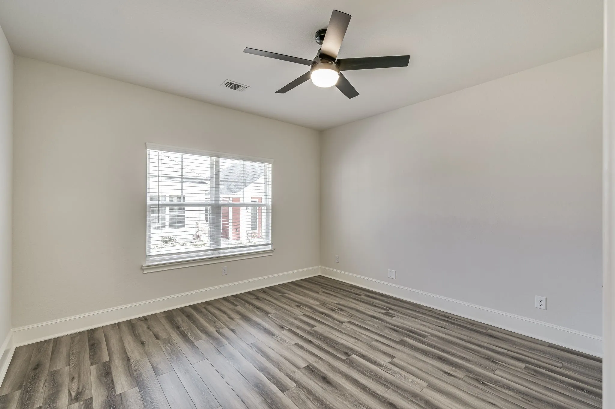 Spare room featuring light wood finished floors and a ceiling fan