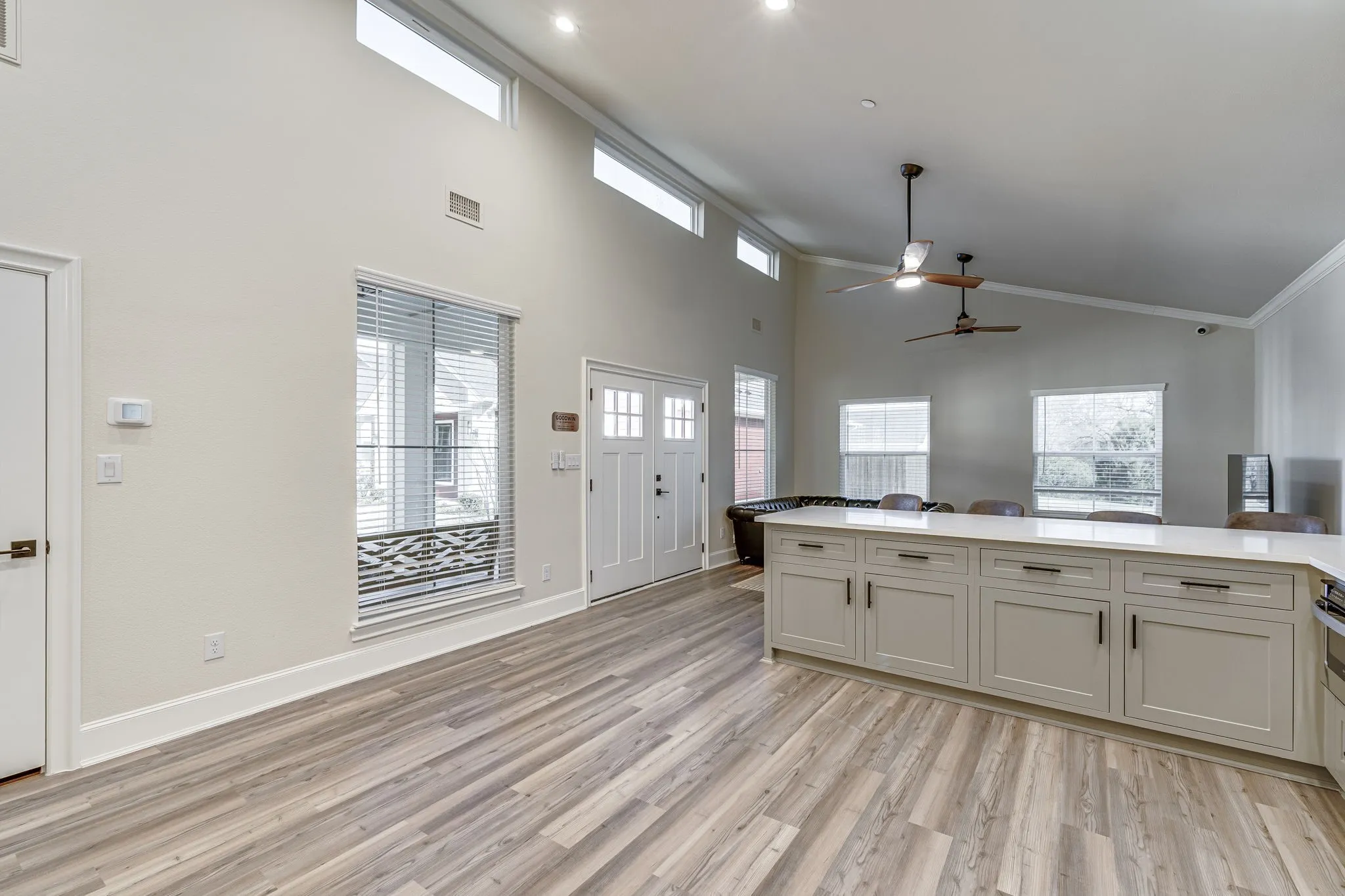 Kitchen featuring light wood finished floors, a ceiling fan, open floor plan, a peninsula, and vaulted ceiling