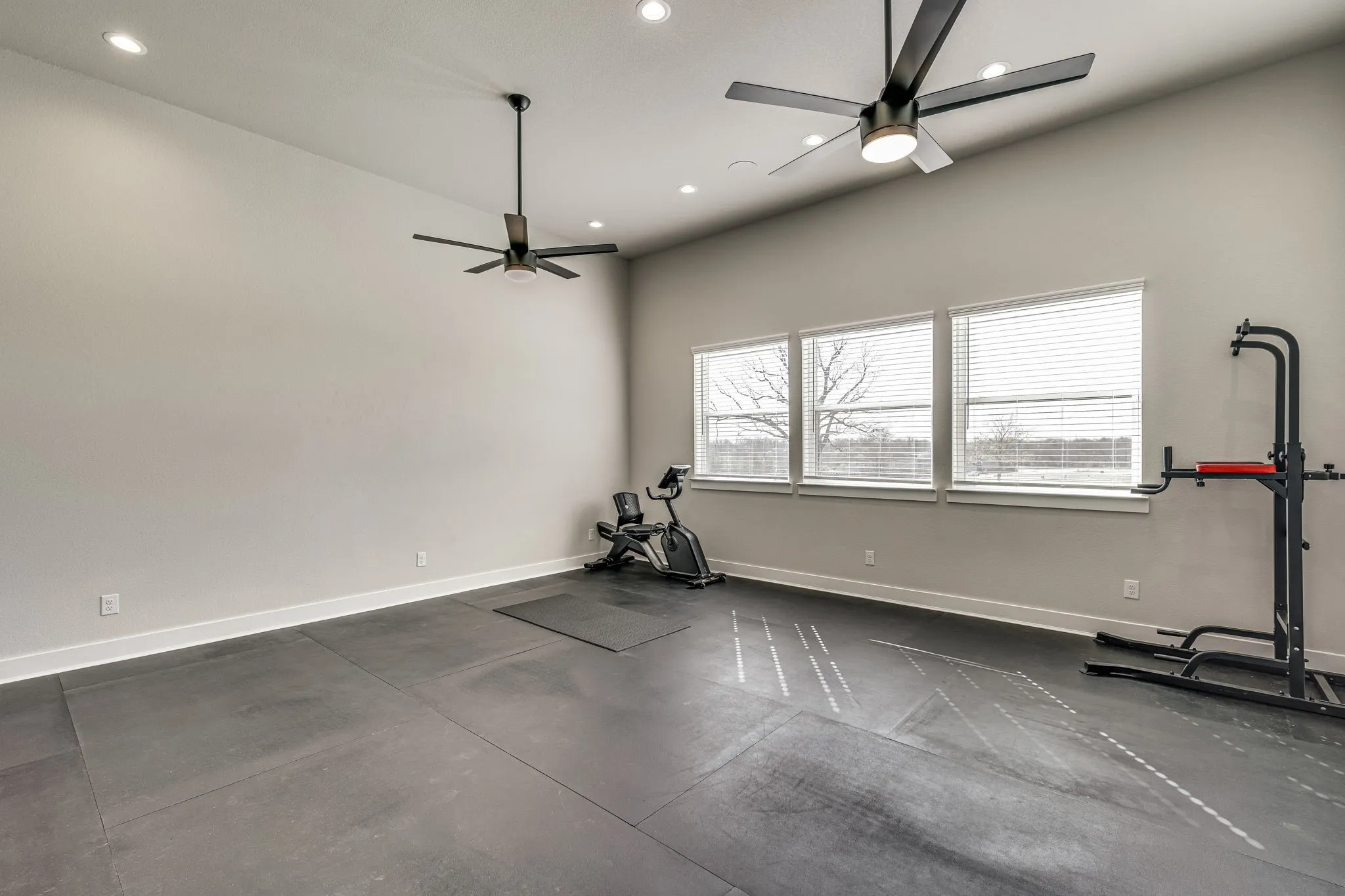 Exercise room featuring a ceiling fan, recessed lighting, and concrete flooring