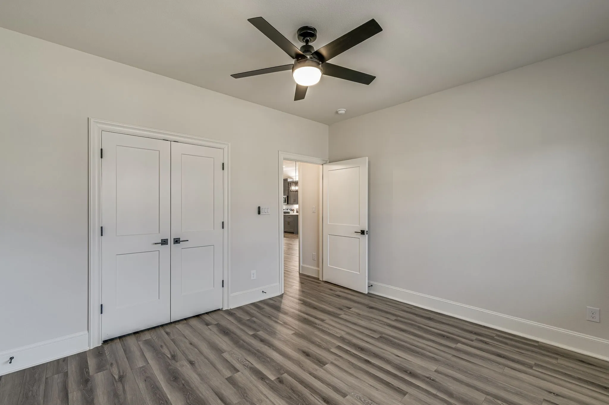 Unfurnished bedroom with dark wood-style flooring, a ceiling fan, and a closet