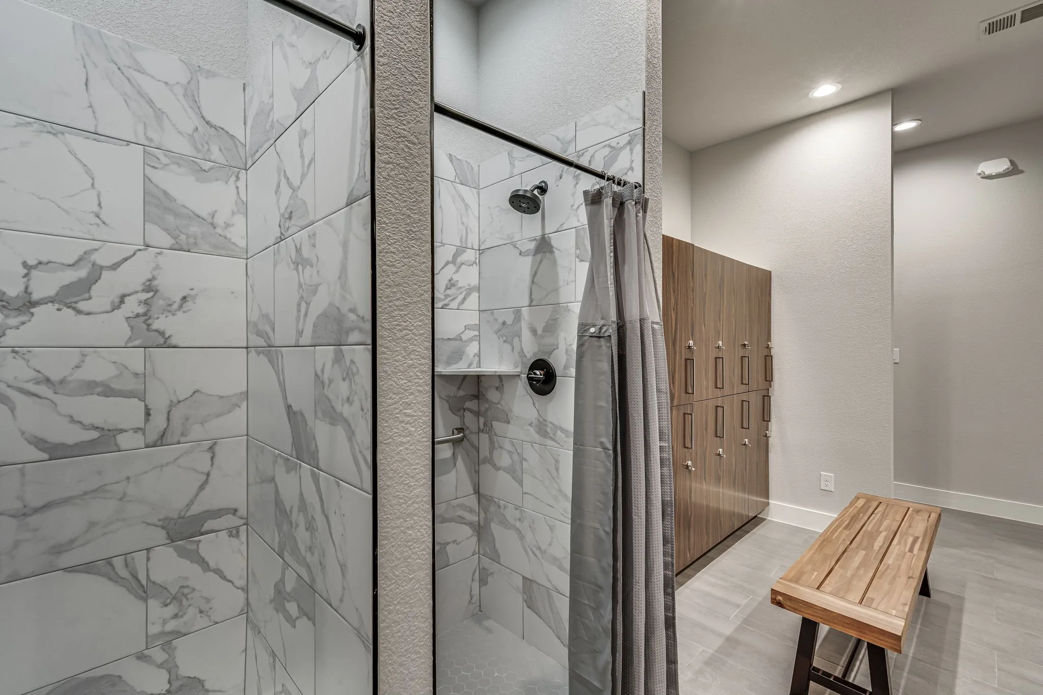 Bathroom with a shower stall and baseboards