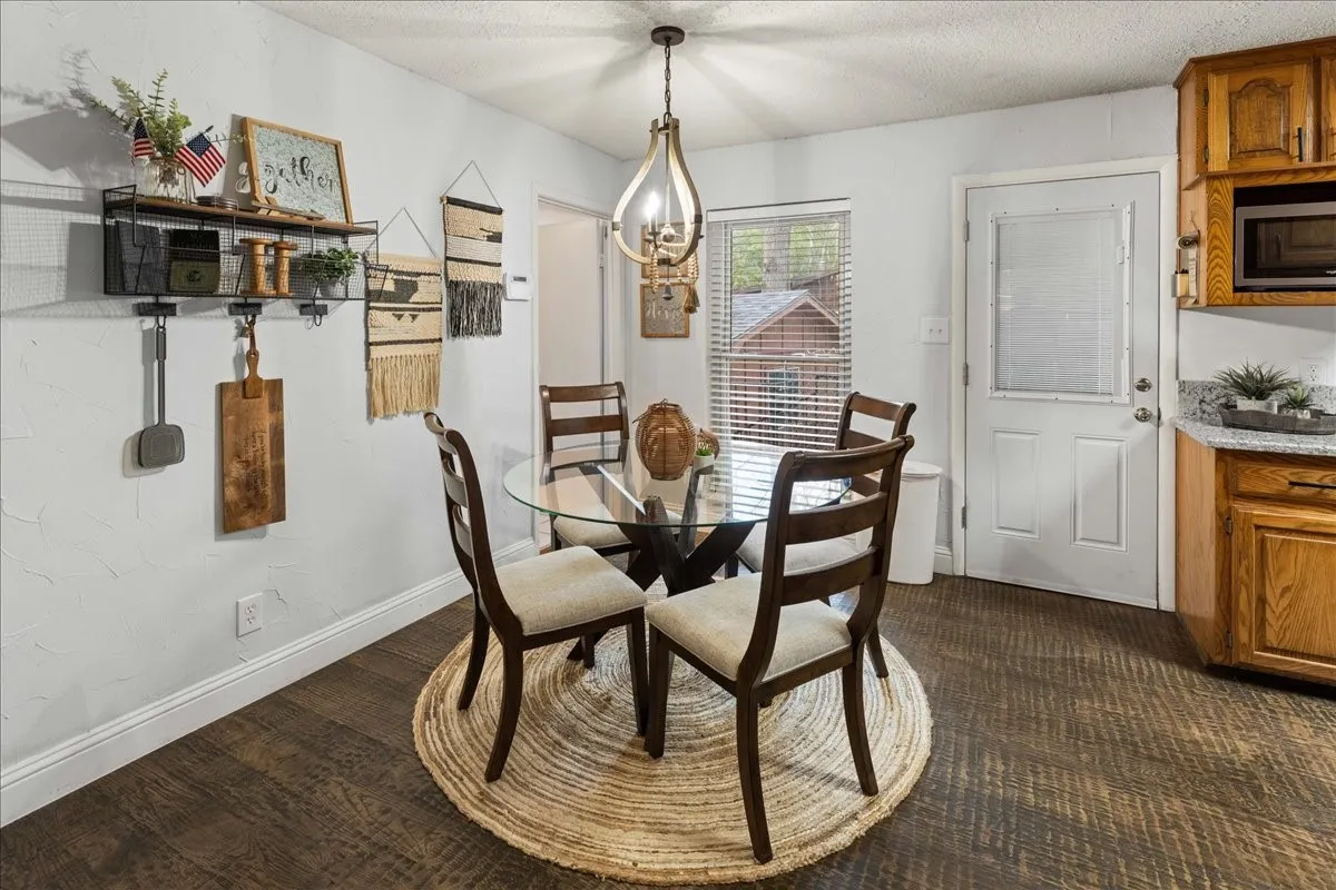 Dining space featuring a textured ceiling and dark wood-style floors