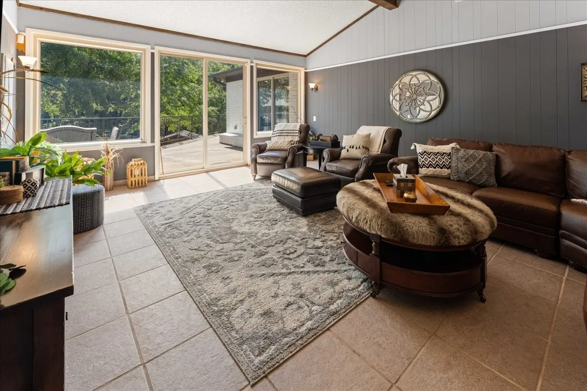 Living area with light tile patterned floors and wood walls