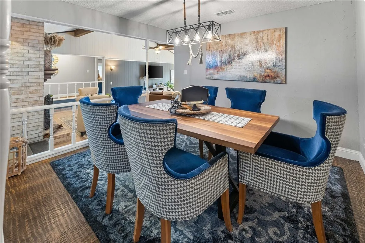 Dining room with ceiling fan, dark carpet, a textured ceiling, and beam ceiling