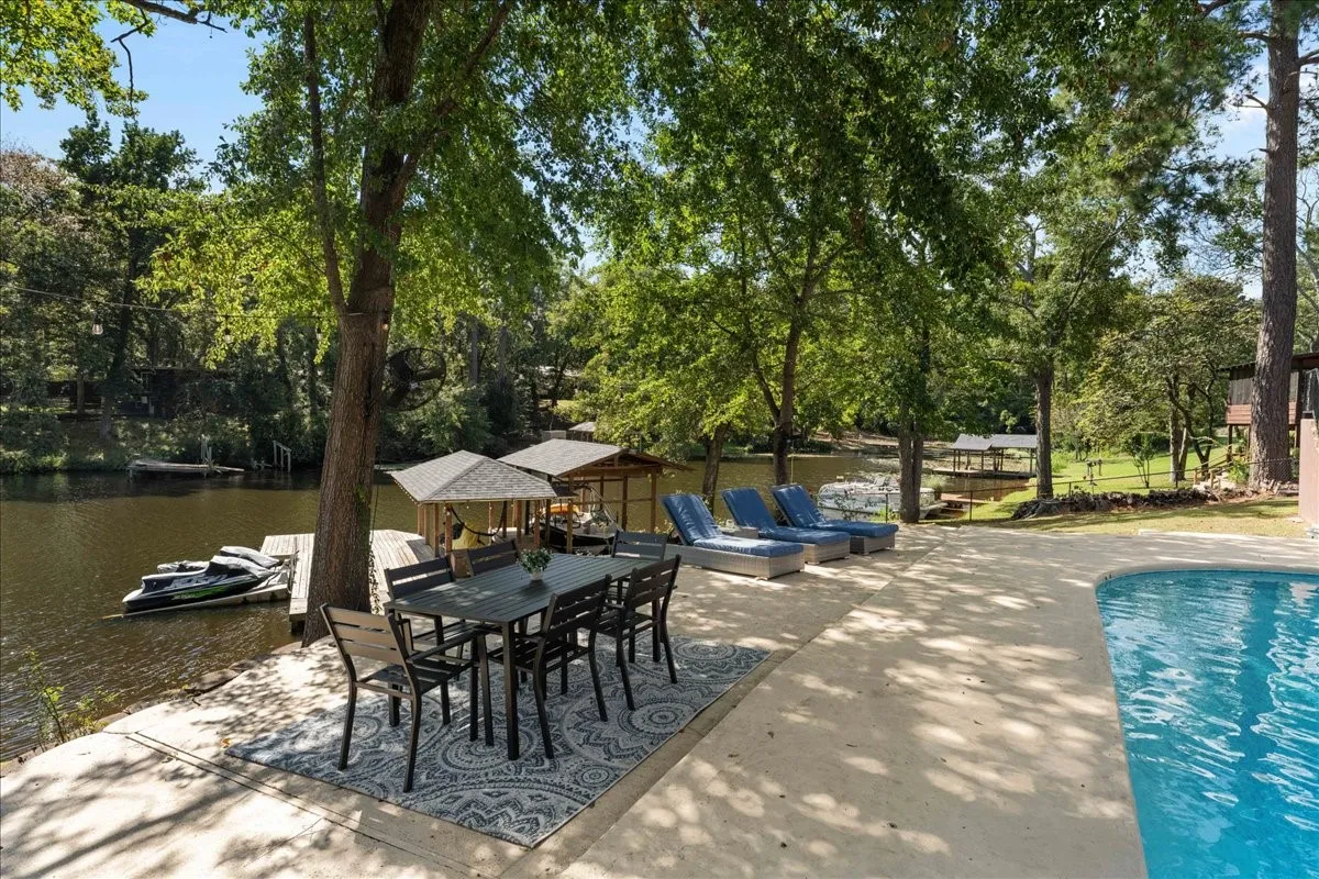 View of patio / terrace with view of wooded area and a water view