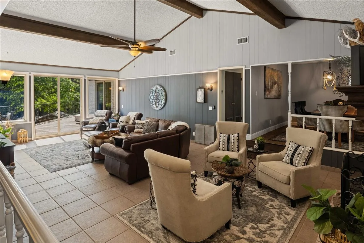 Living room with a textured ceiling, tile patterned flooring, and ceiling fan