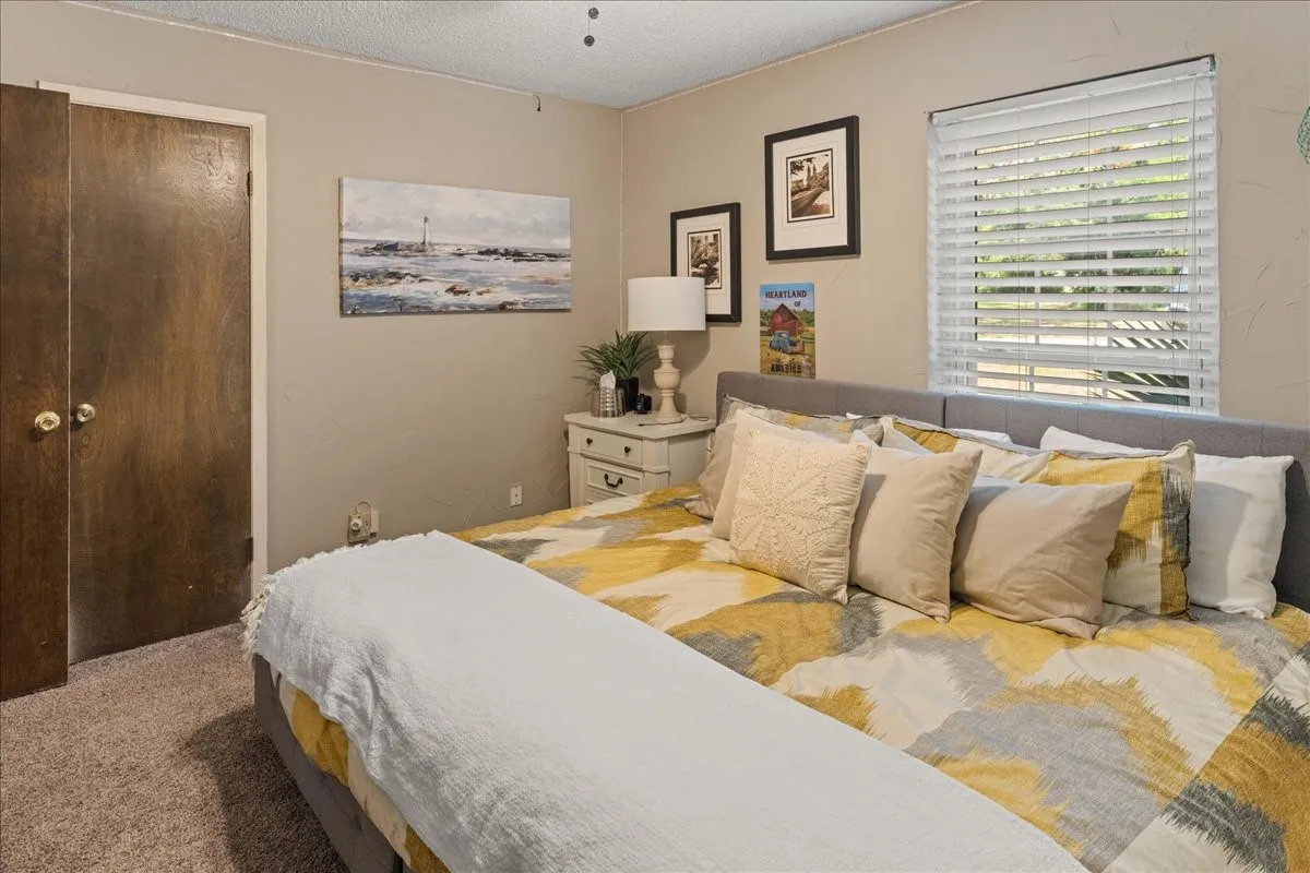 Bedroom with carpet flooring, a textured ceiling, and a closet
