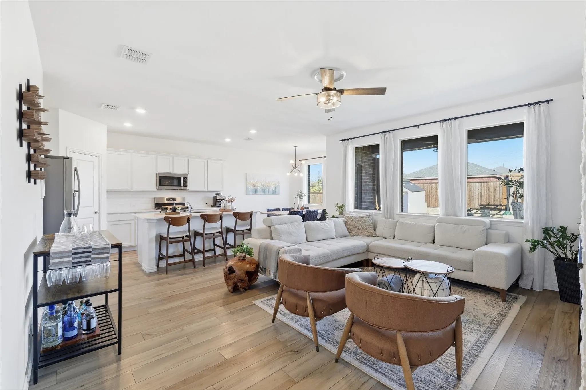 Living area featuring light LVP floors, suspended lighting, and a ceiling fan