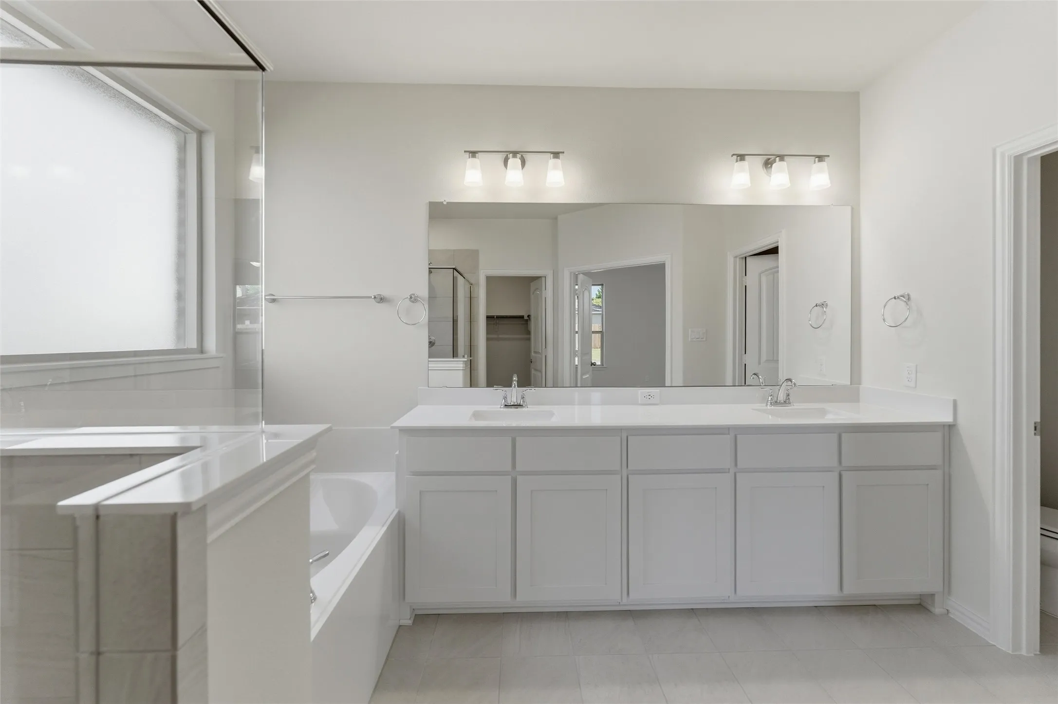 Full bathroom with double vanity, a shower stall, and a garden tub