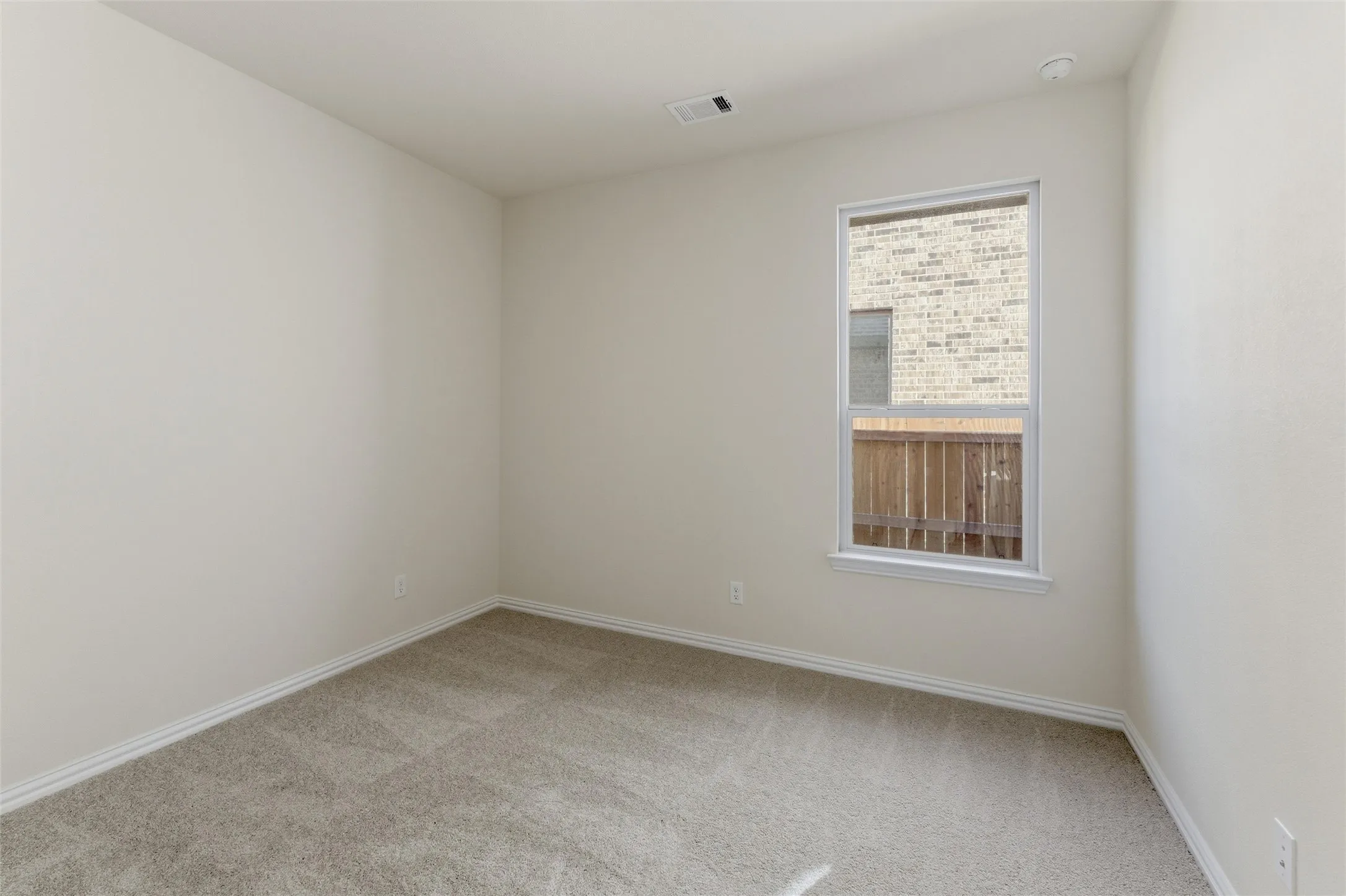 Spare room with light carpet and baseboards