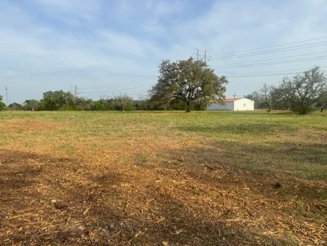 View of grassy yard with an outbuilding and a view of rural / pastoral area