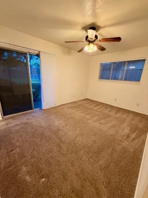 Primary Bedroom with sliding glass door to backyard & patio.