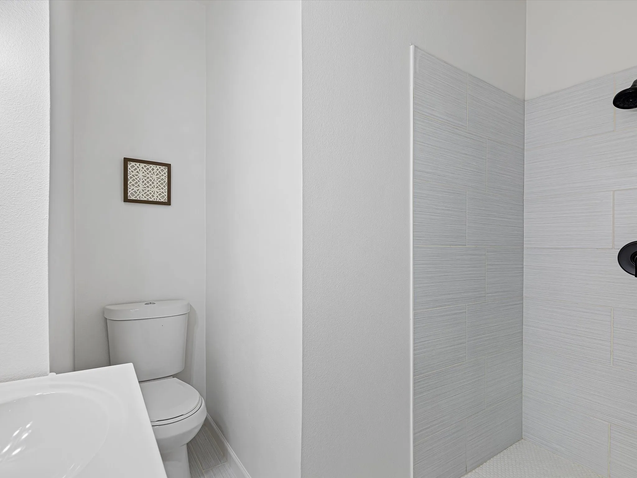 End full bathroom off front hall features fresh paint, vanity, and nice tile shower
