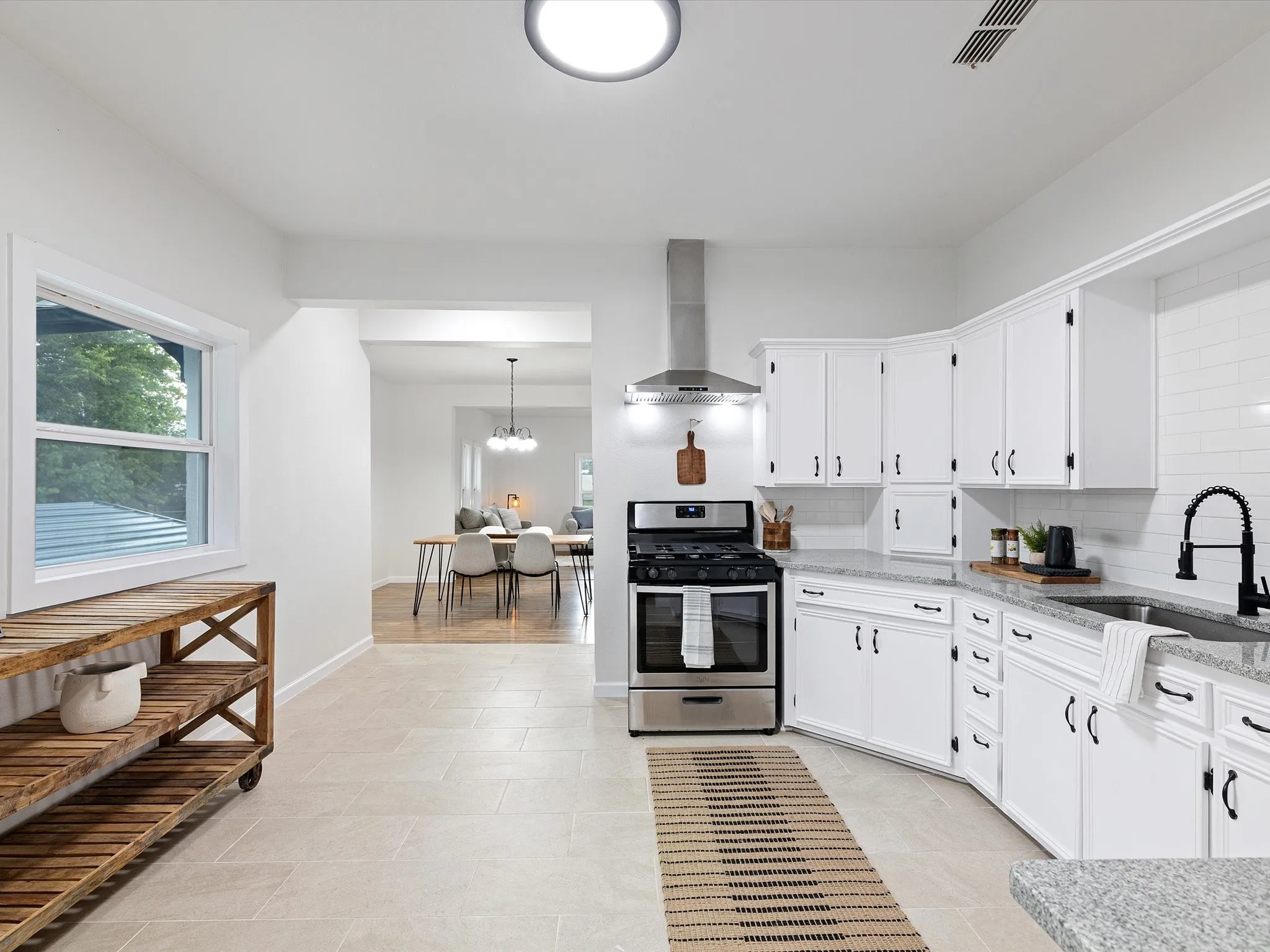 Kitchen has granite counter tops, ss appliances, lots of cabinets, added a dishwasher, large sink, updated fixtures and hardware, gas range, eat in area room enough for another table, and more!