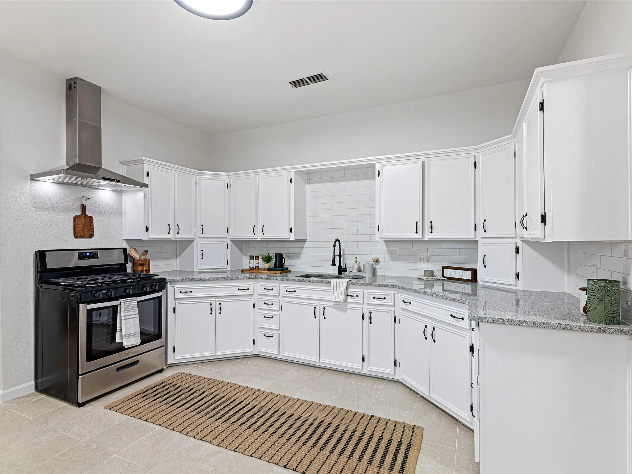 Kitchen has granite counter tops, ss appliances, lots of cabinets, added a dishwasher, large sink, updated fixtures and hardware, gas range, eat in area room enough for another table, and more!