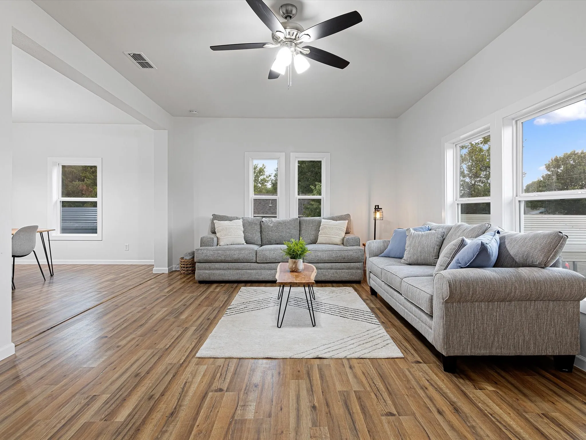 Large living room has nice LVP floors throughout, fresh paint, new windows, ceiling fan, open floorplan, and more!
