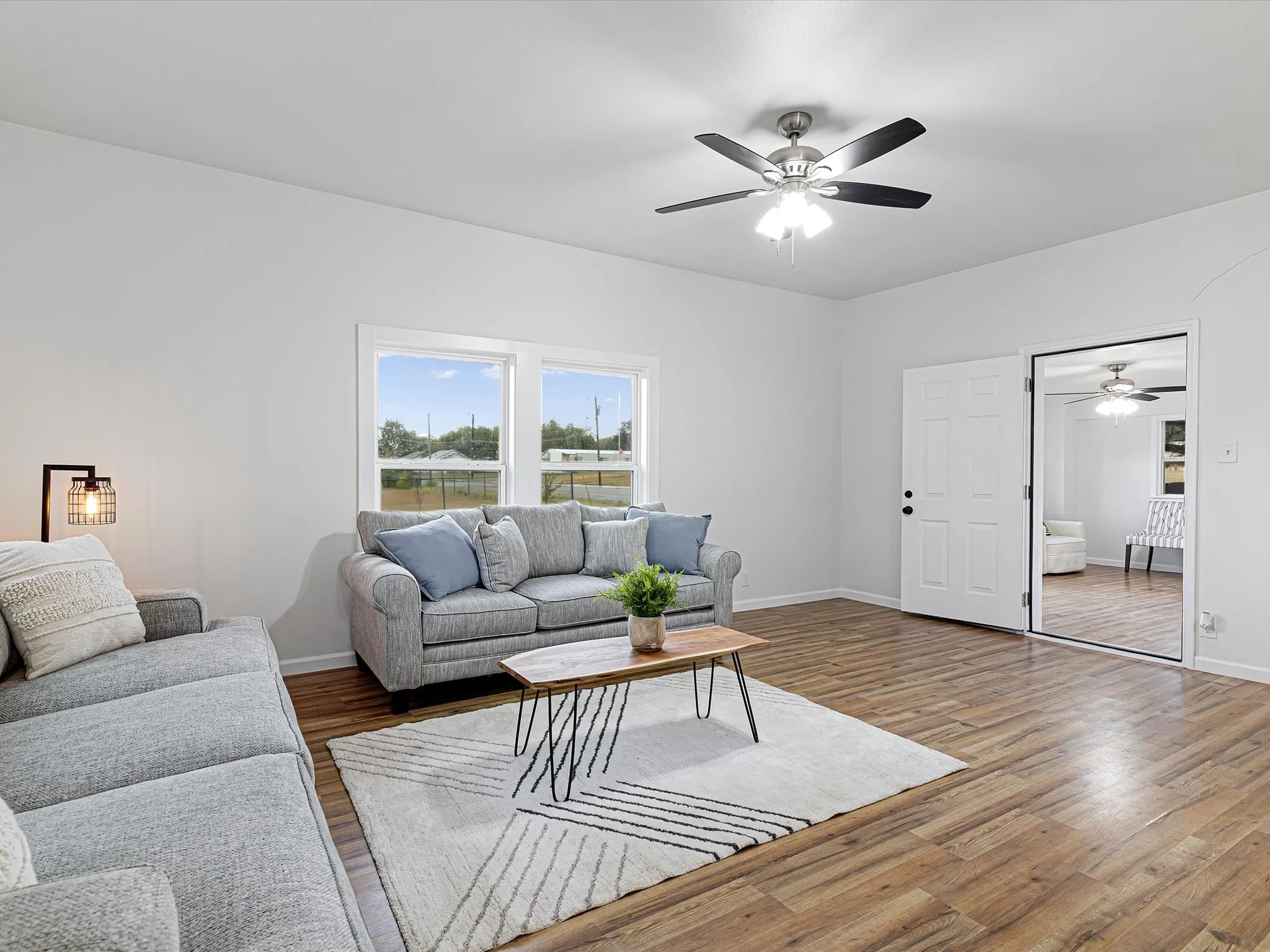 Large living room has nice LVP floors throughout, fresh paint, new windows, ceiling fan, open floorplan, and more!
