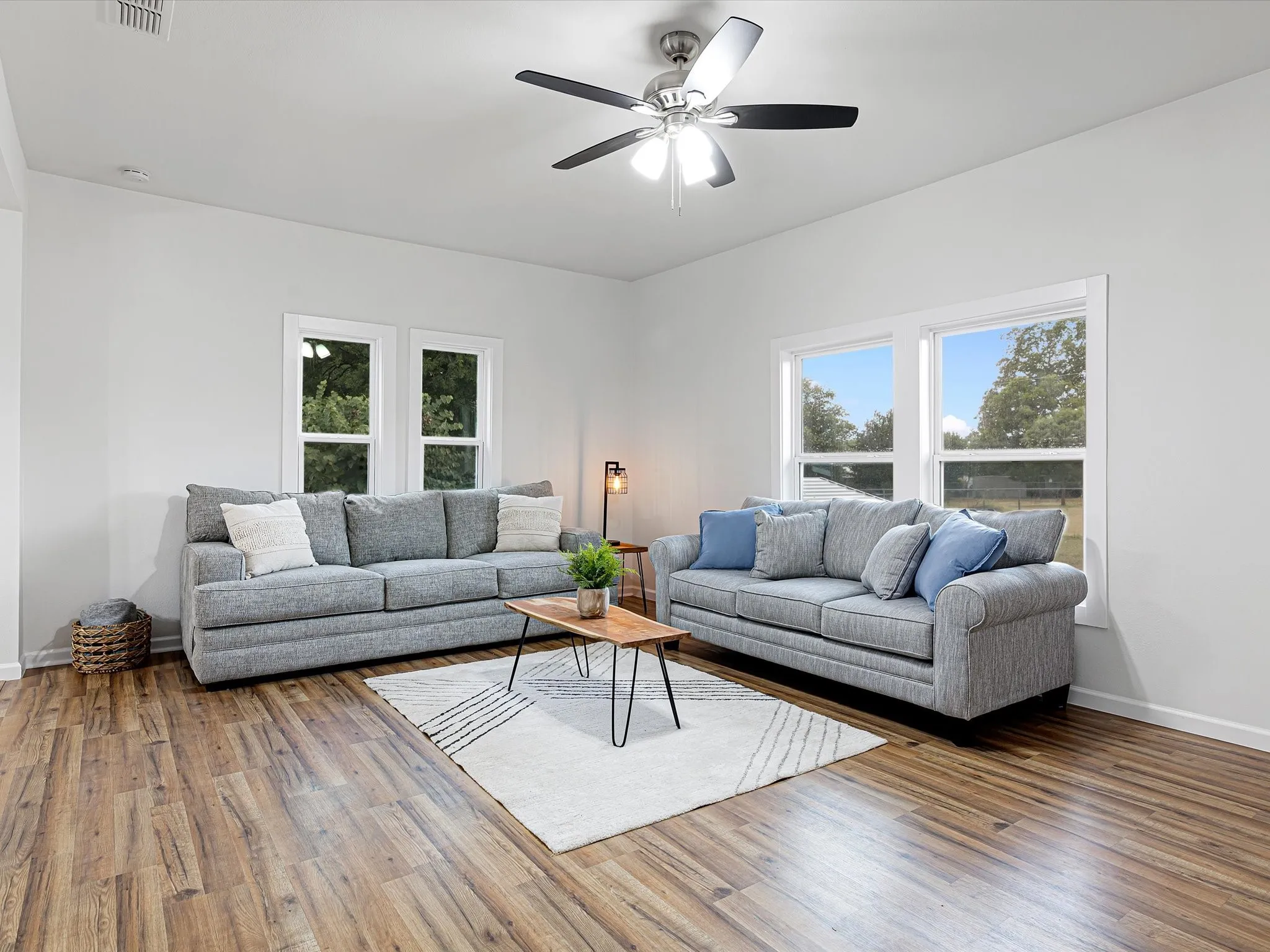 Large living room has nice LVP floors throughout, fresh paint, new windows, ceiling fan, open floorplan, and more!