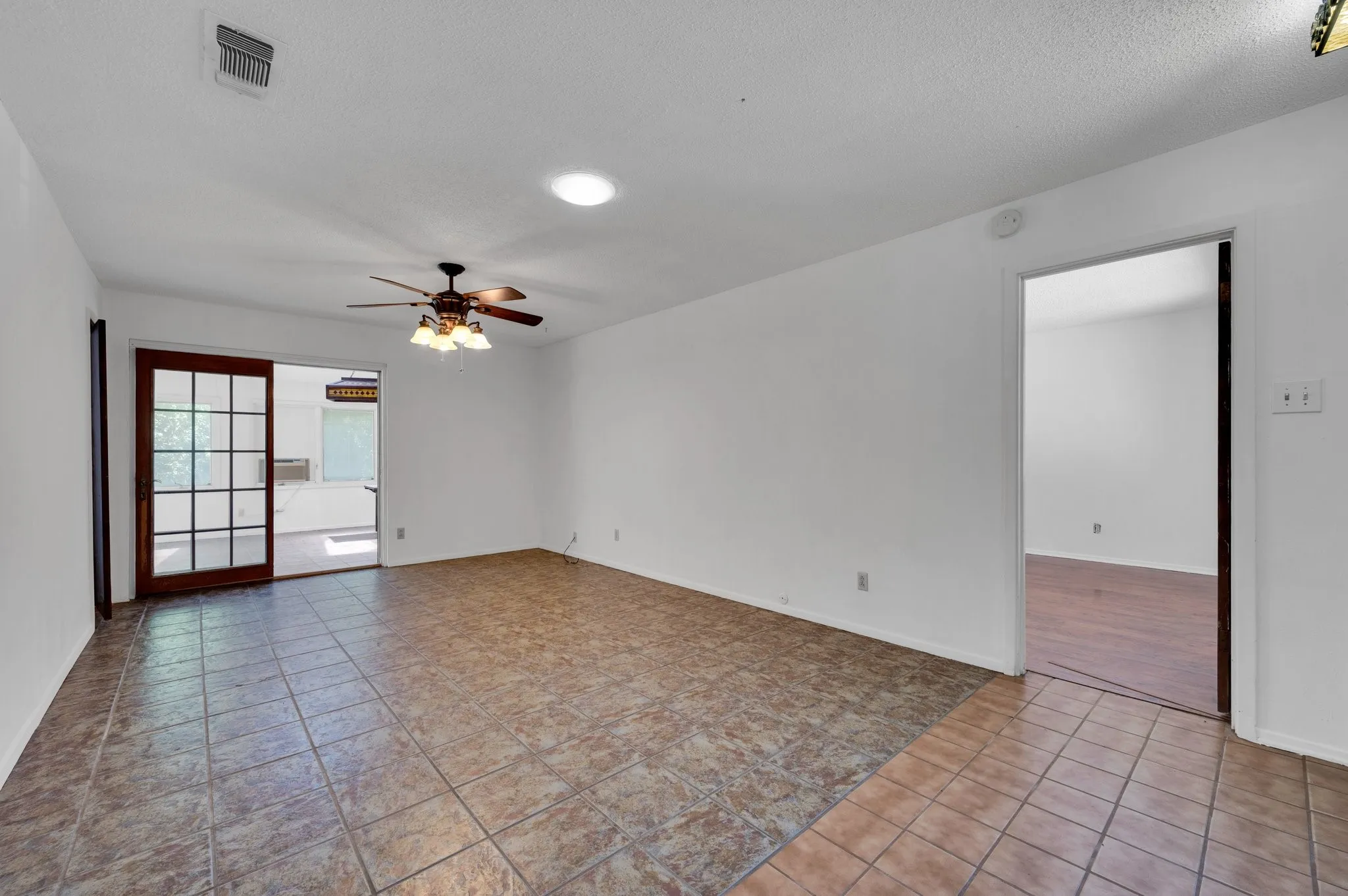 Living Unfurnished room with ceiling fan, a textured ceiling, and light tile patterned floors