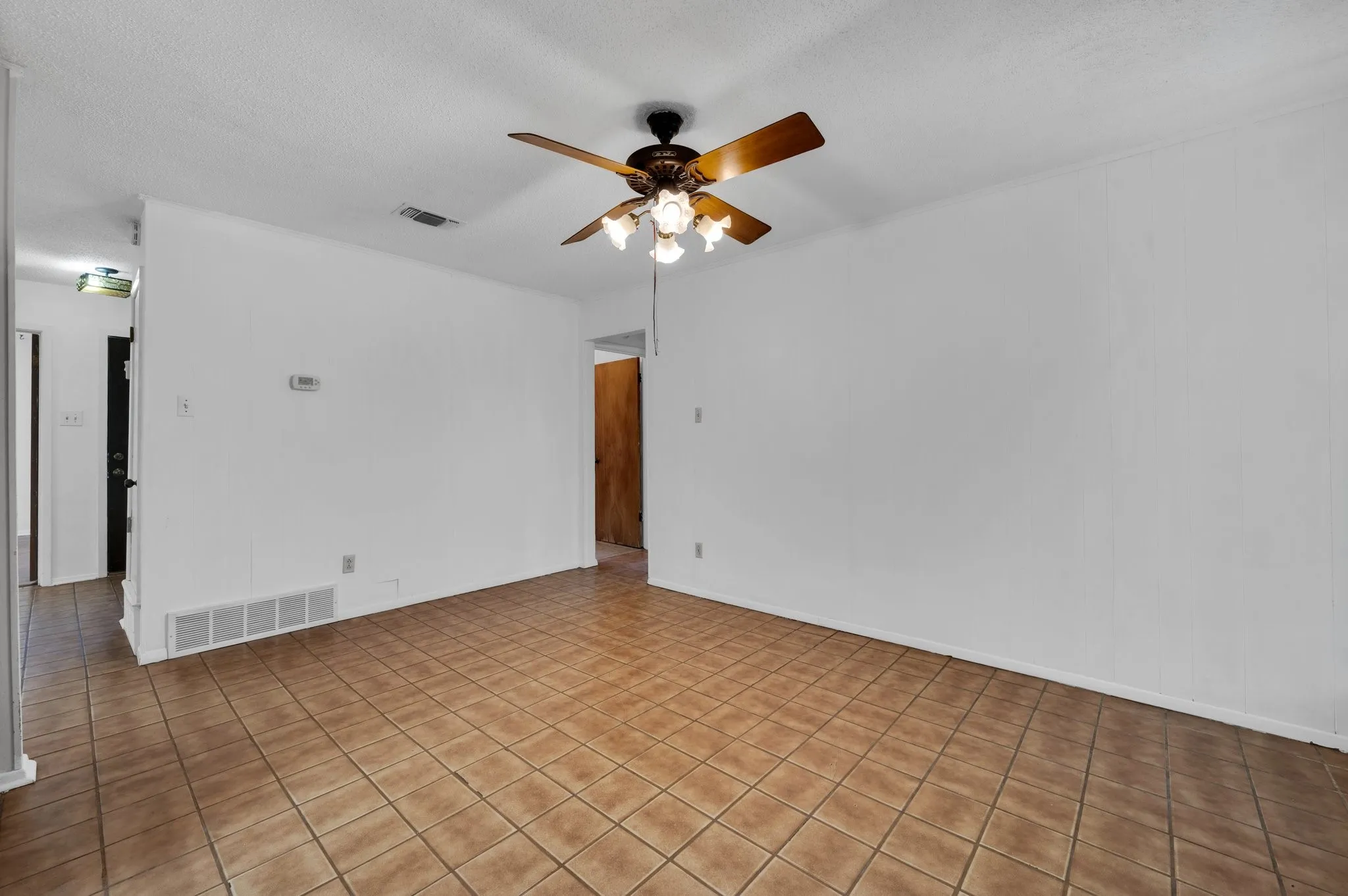 Unfurnished room with ceiling fan and a textured ceiling
