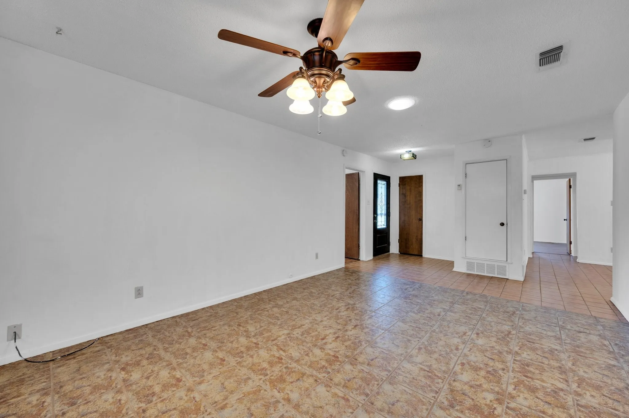Empty room with ceiling fan and tile patterned floors